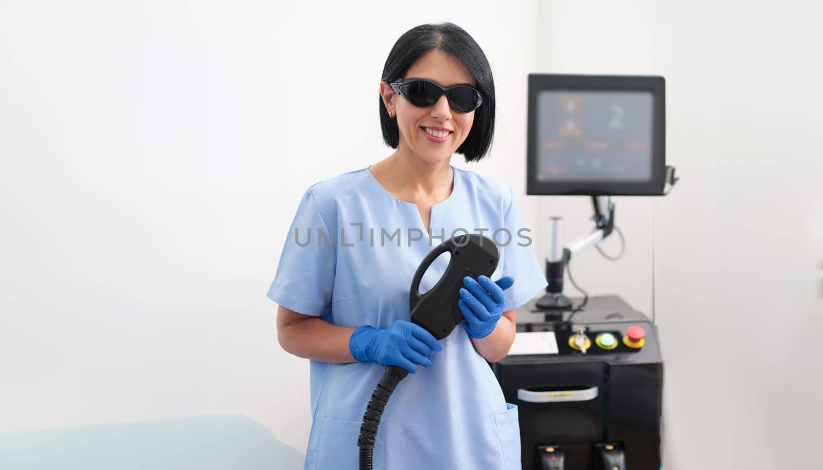 Device for laser hair removal and the hands of cosmetologist cosmetologist in medical gloves by kuprevich