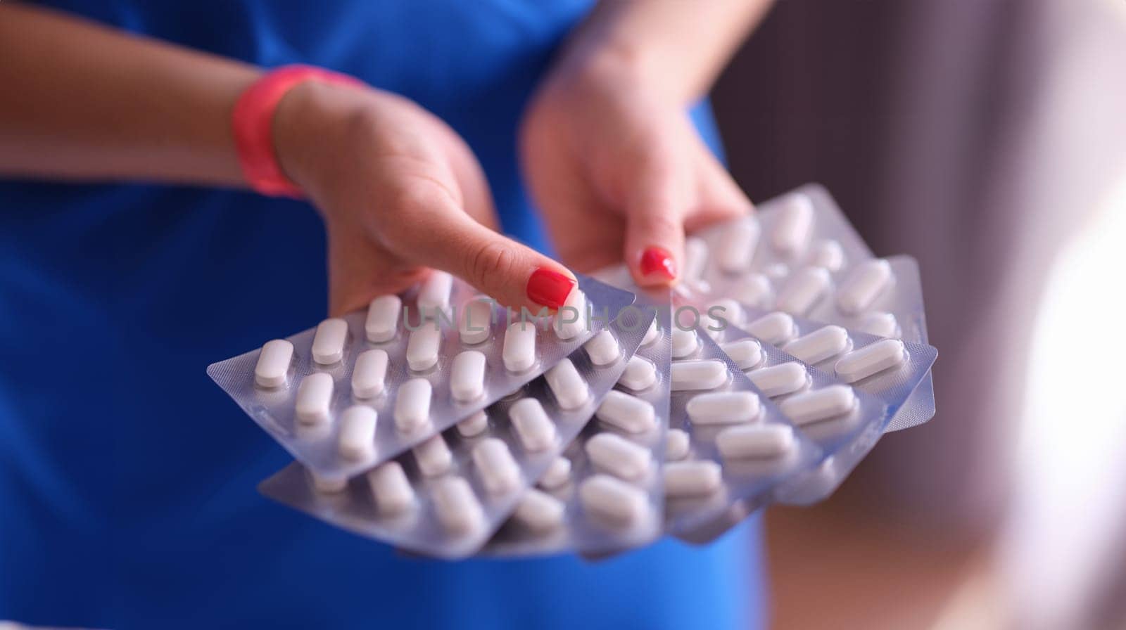 Woman hands hold lot of blisters with medical pills closeup by kuprevich