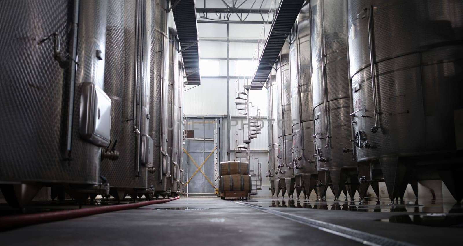 Modern winery interior with large metal tanks by kuprevich