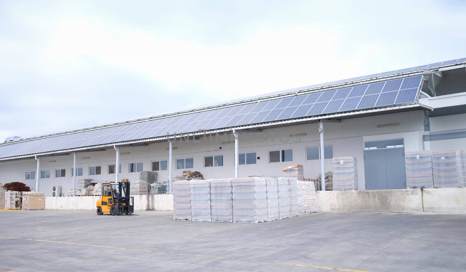 Forklift and pallets with goods in large warehouse outside warehouse by kuprevich