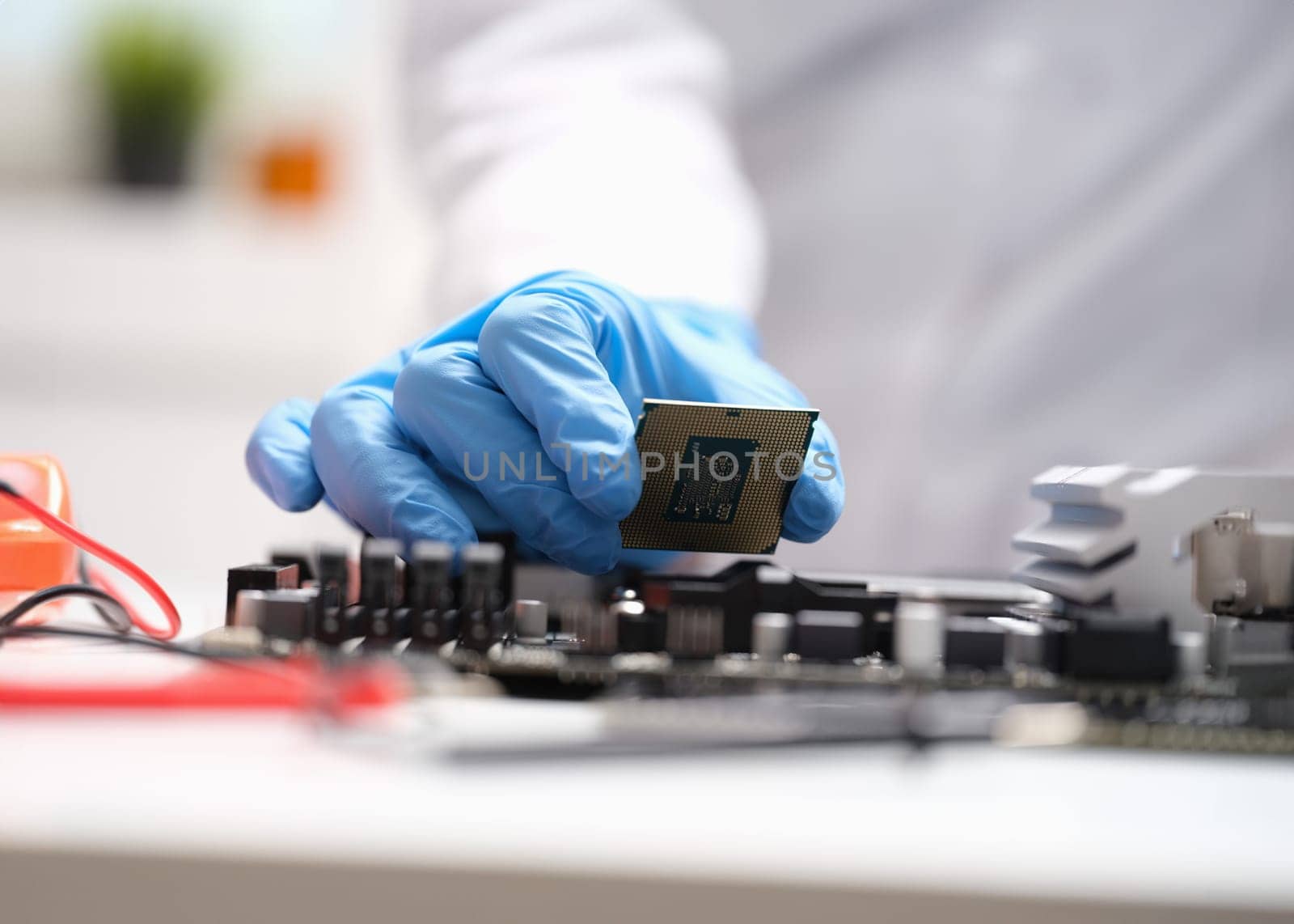 Technician connects a CPU microprocessor to motherboard socket. Repair and maintenance of computer equipment concept