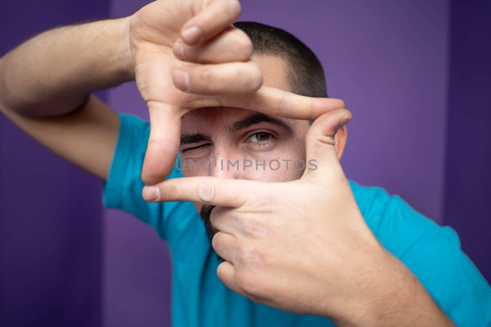 Young handsome man doing frame using hands palms and fingers, over purple background by PaulCarr