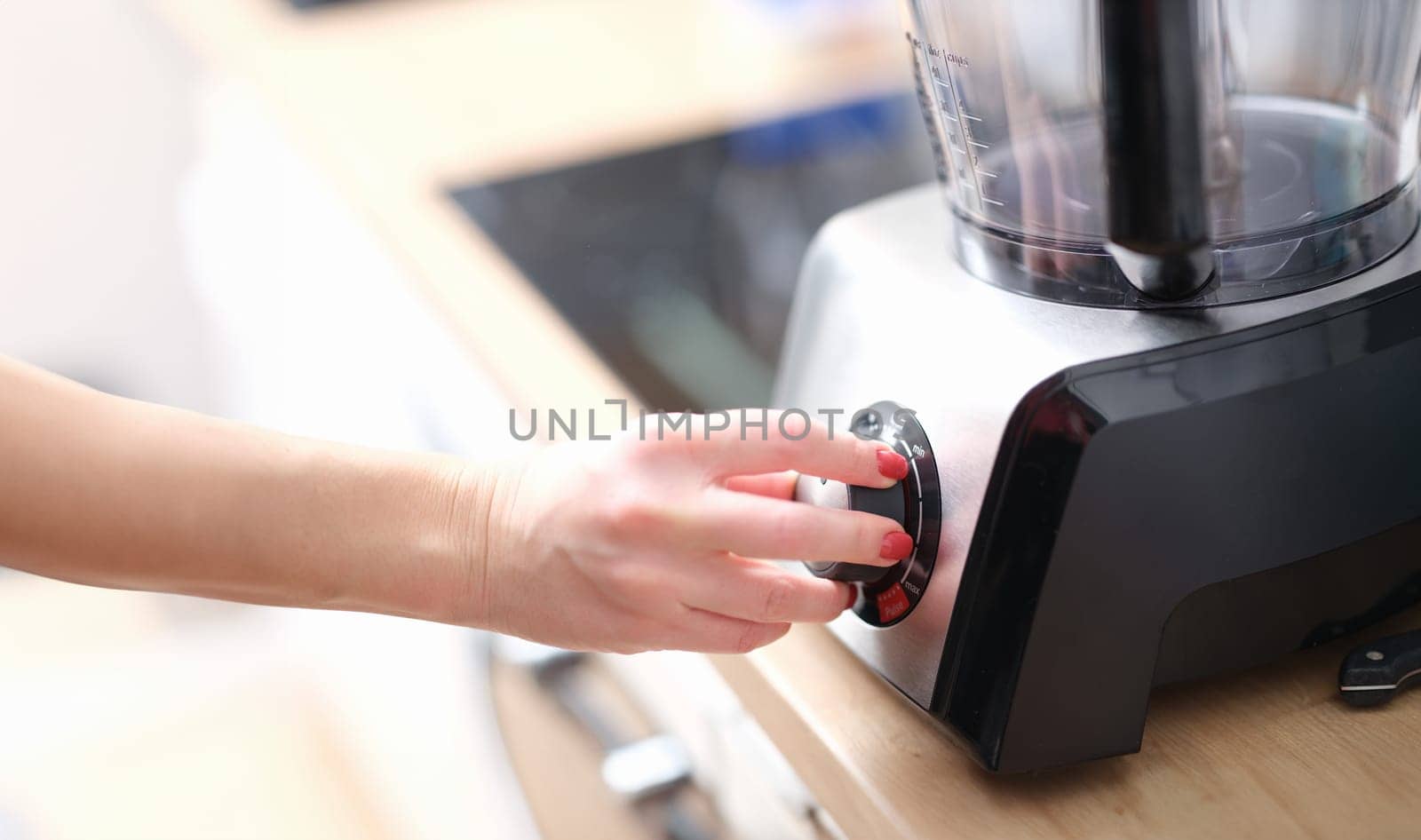 Woman hands switch gears on mixer in kitchen. Mixing products concept