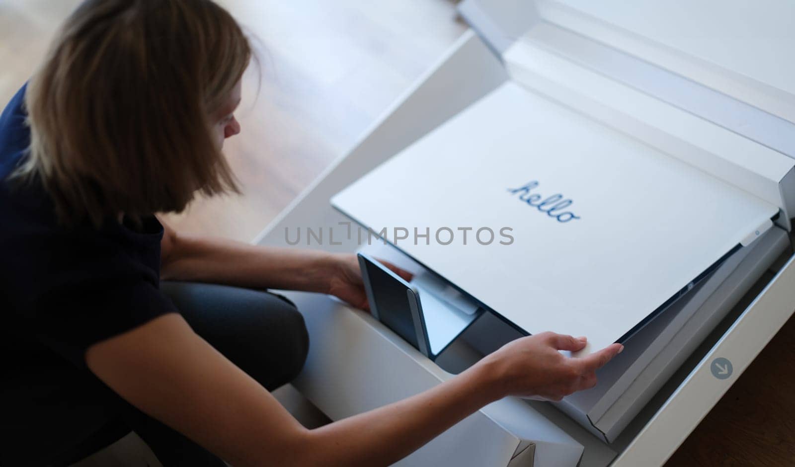 Tbilisi, Georgia - August 18, 2022: Woman takes out new iMac monitor from box by kuprevich