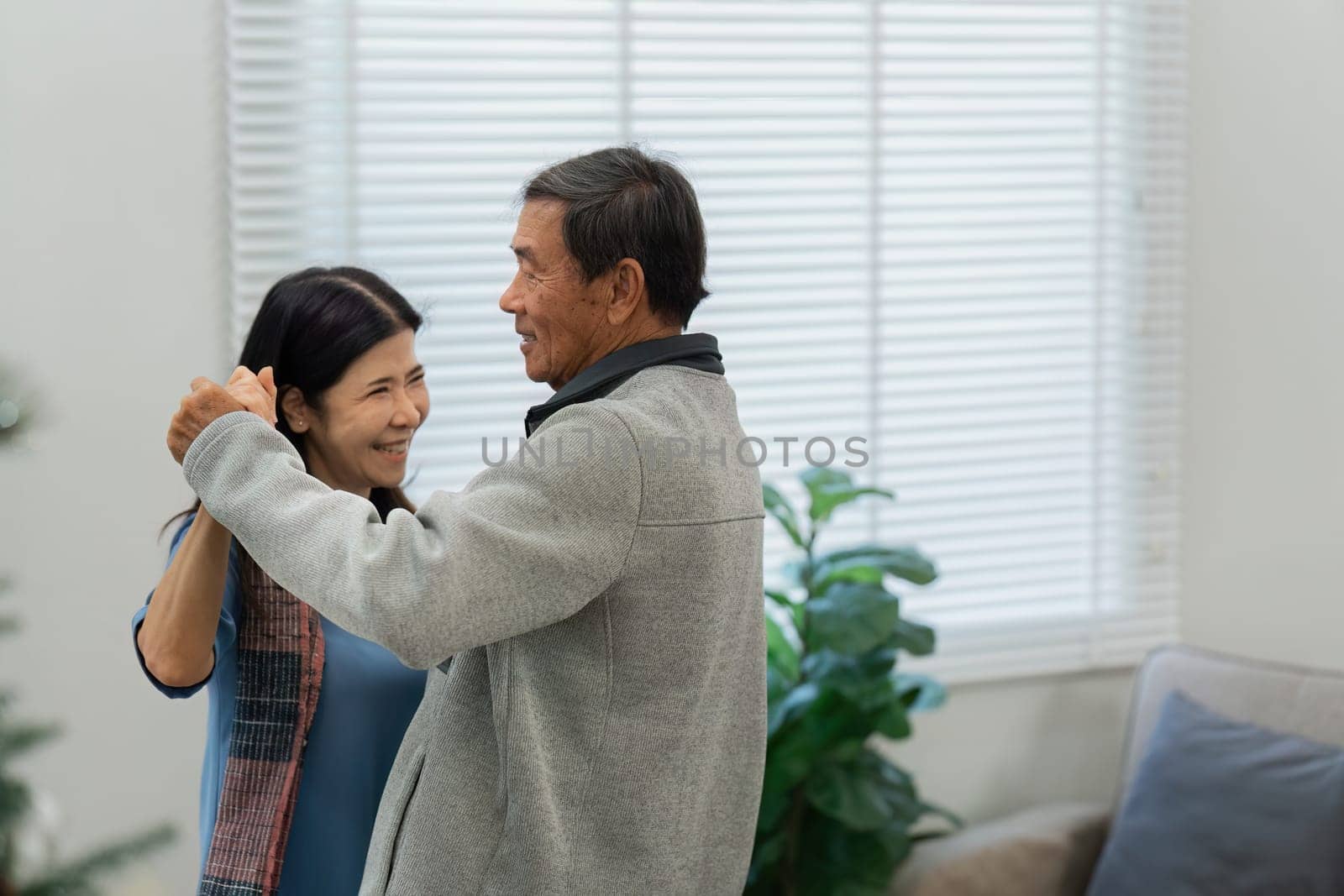 Happy cheerful middle aged mature couple family parent dancing together in the living room by itchaznong