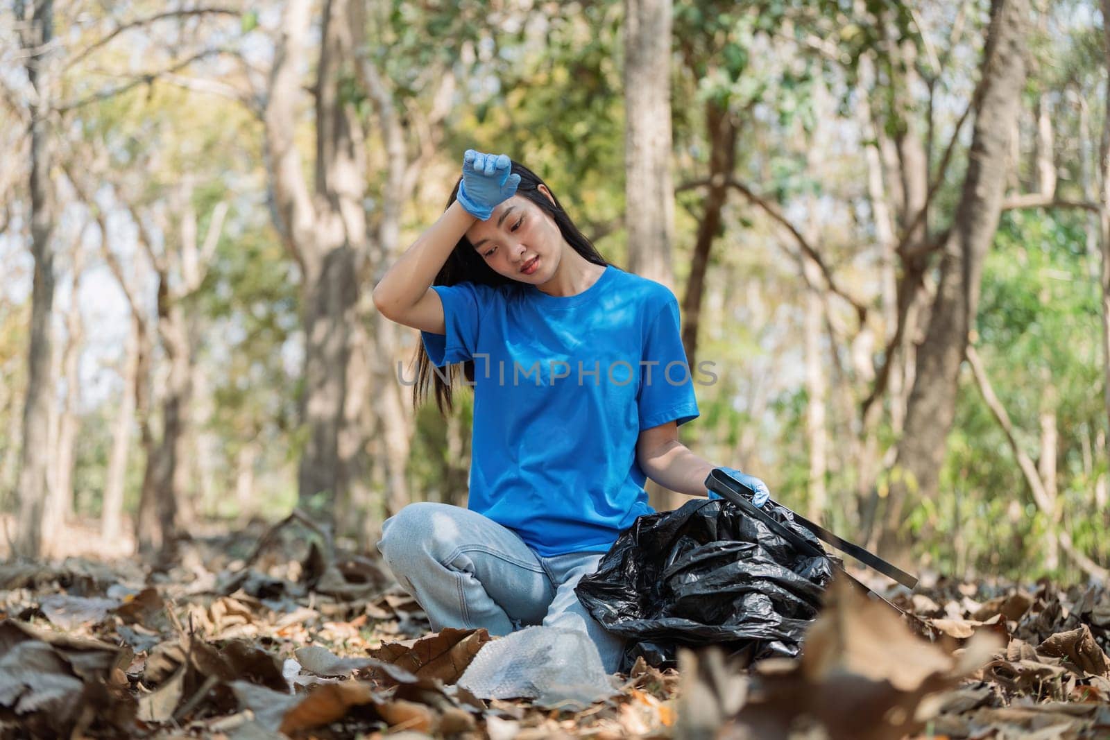 Young volunteer with garbage bag cleaning area in forest, People and ecology. Volunteer concept.