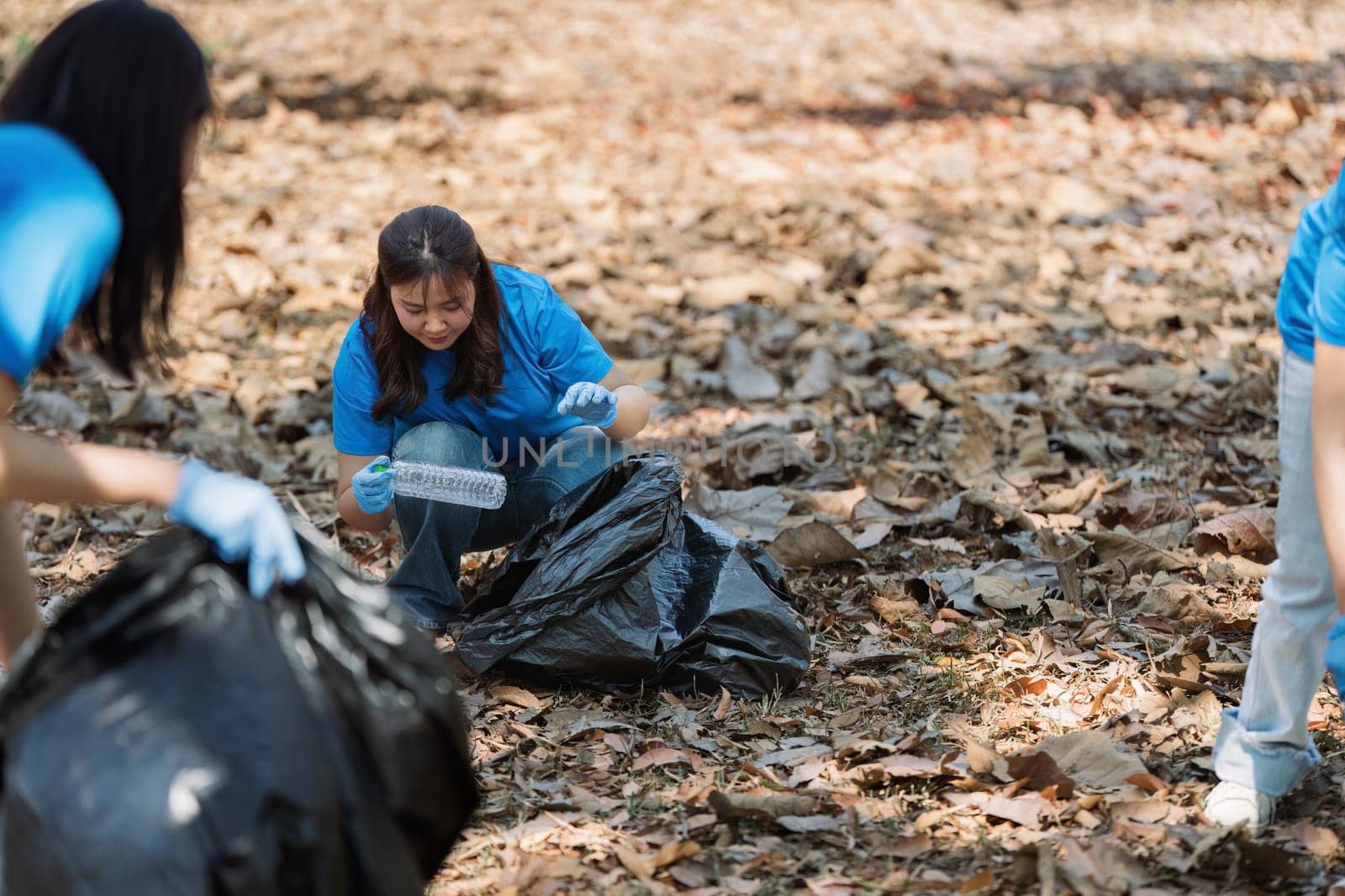 Young volunteer with garbage bag cleaning area in forest, People and ecology. Volunteer concept by itchaznong