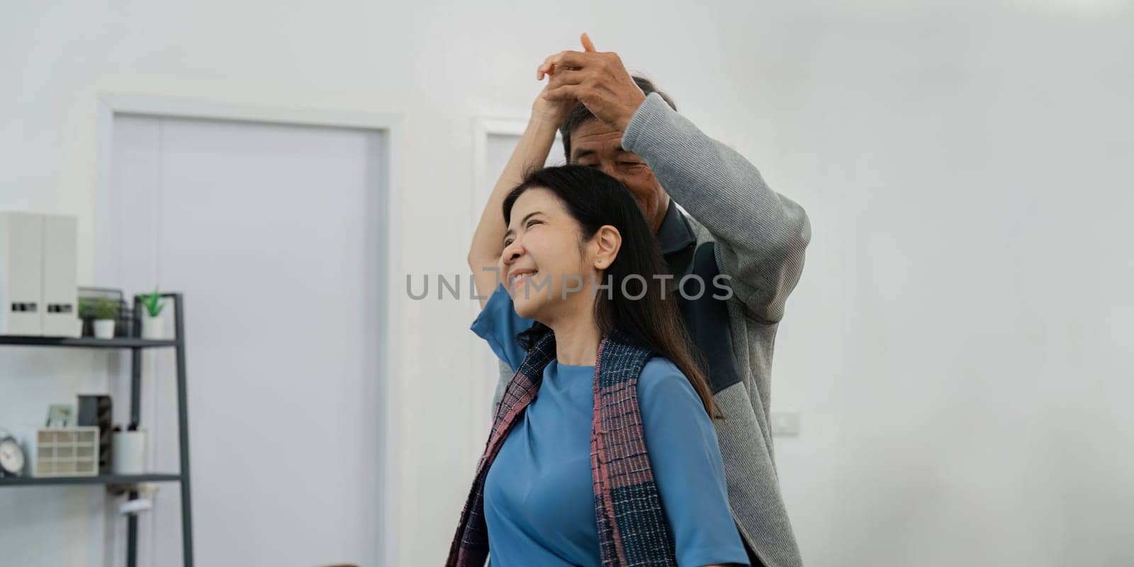 Happy cheerful middle aged mature couple family parent dancing together in the living room by itchaznong