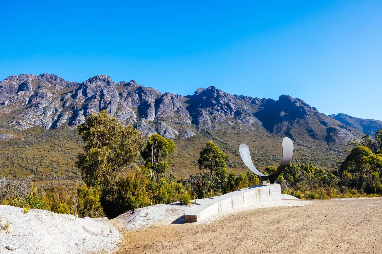 The picturesque Gordon River Rd at the Sentinel range of mountains near Bitumen Bones Sculpture on a hot summer's afternoon in Southwest National Park, Tasmania, Australia