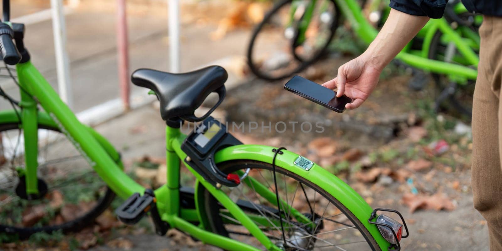 Businessman using mobile app, scanning QR code for rental bicycle on the work, eco transport concept.