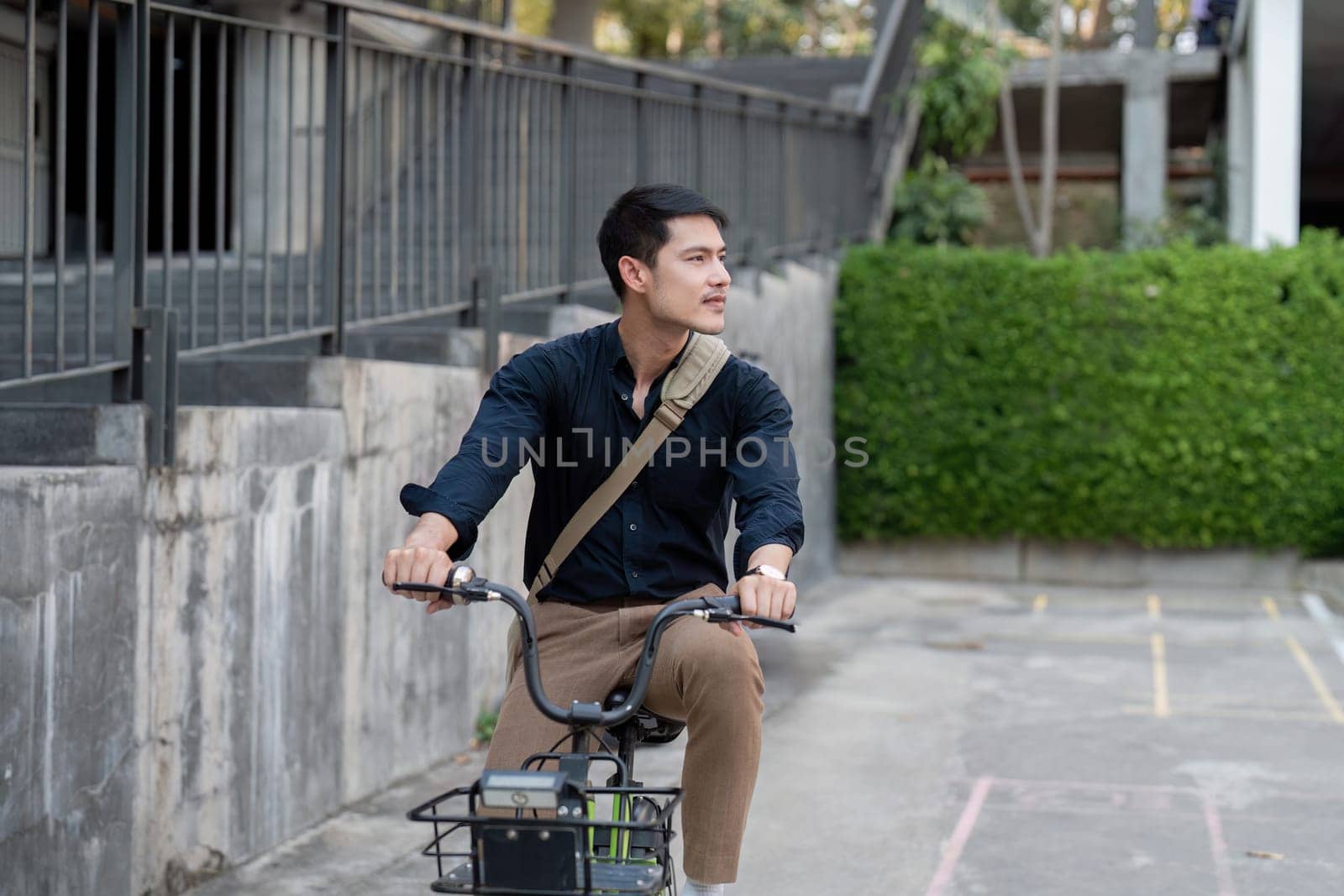 Eco friendly, Happy lifestyle asian young businessman ride bicycle go to office work at city street with bicycle in morning by nateemee