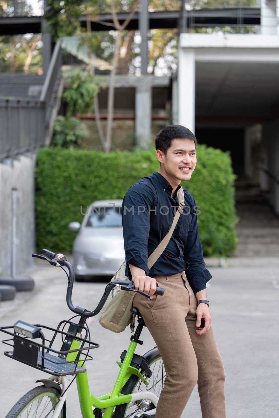 Eco friendly, Happy lifestyle asian young businessman ride bicycle go to office work at city street with bicycle in morning by nateemee