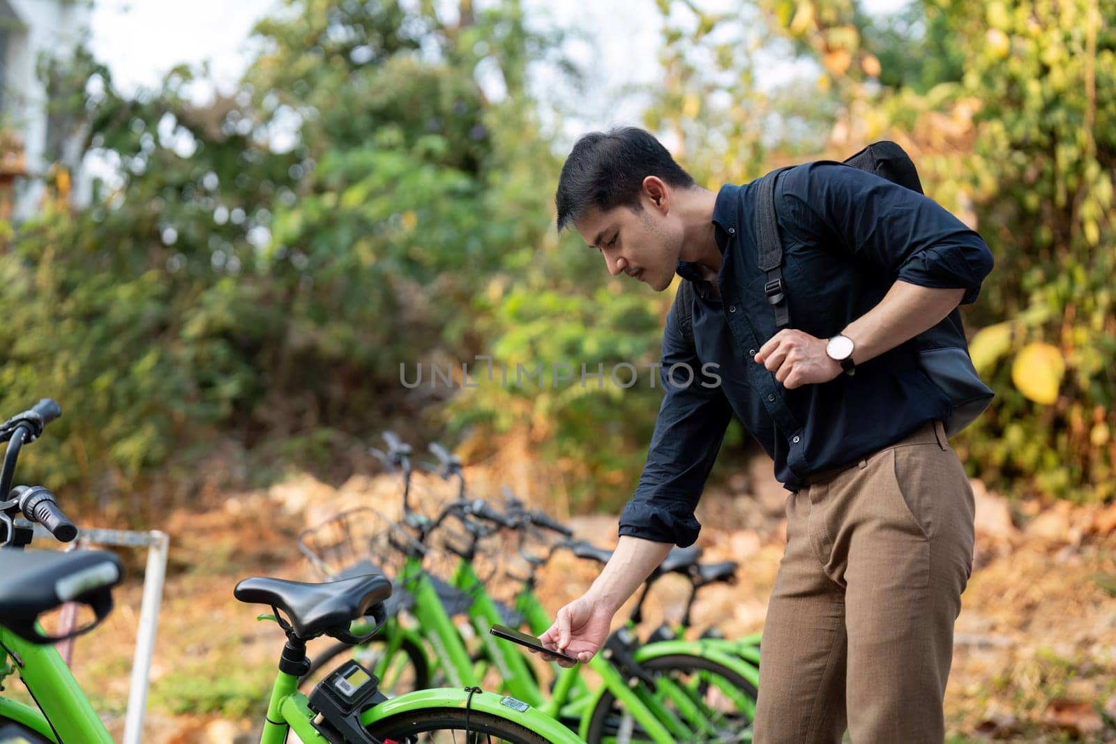 Businessman using mobile app, scanning QR code for rental bicycle on the work, eco transport concept.
