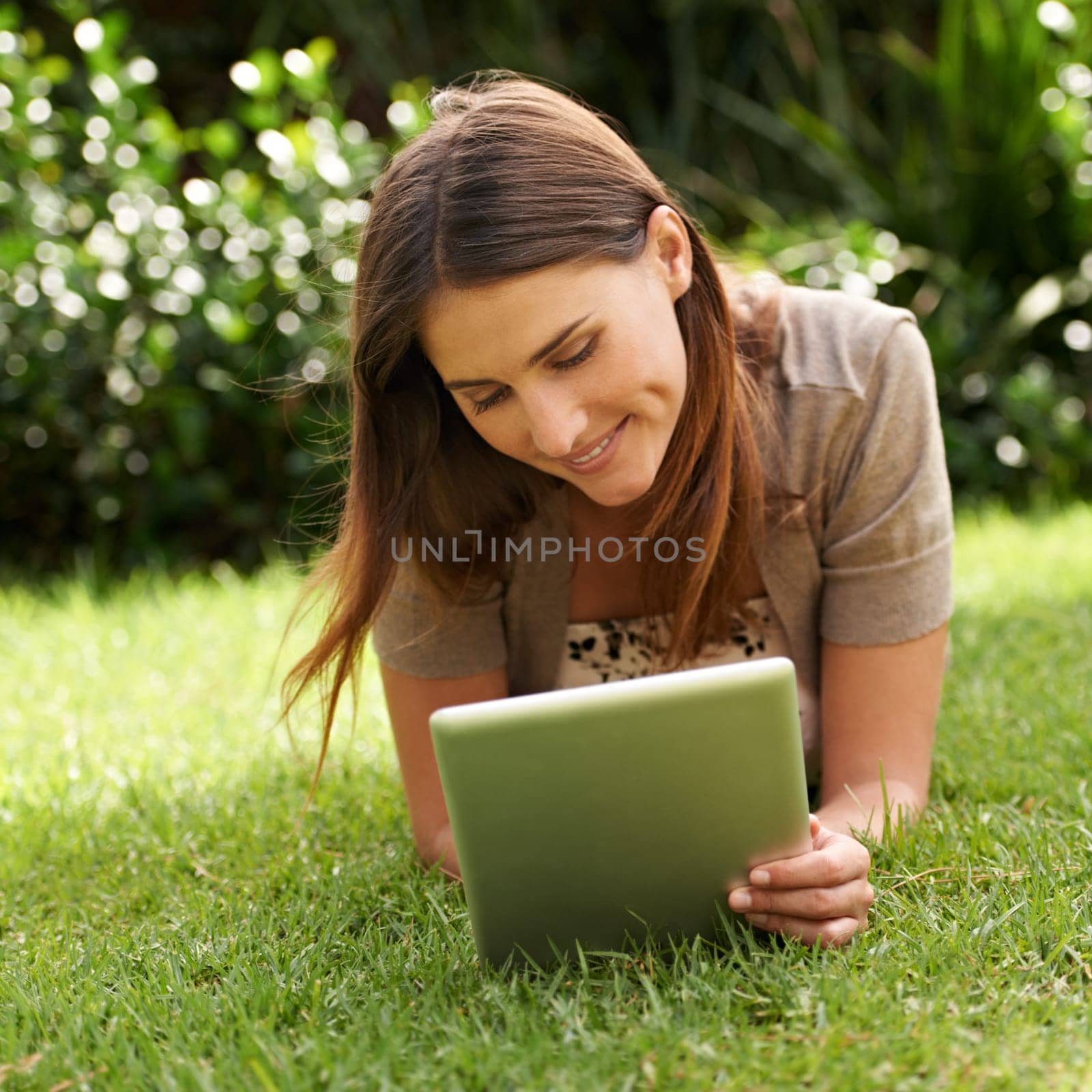 Tablet, smile and woman outdoor on grass, nature and garden for communication, technology and internet. Happy female person, backyard and digital pad for social media, connectivity and browsing by YuriArcurs