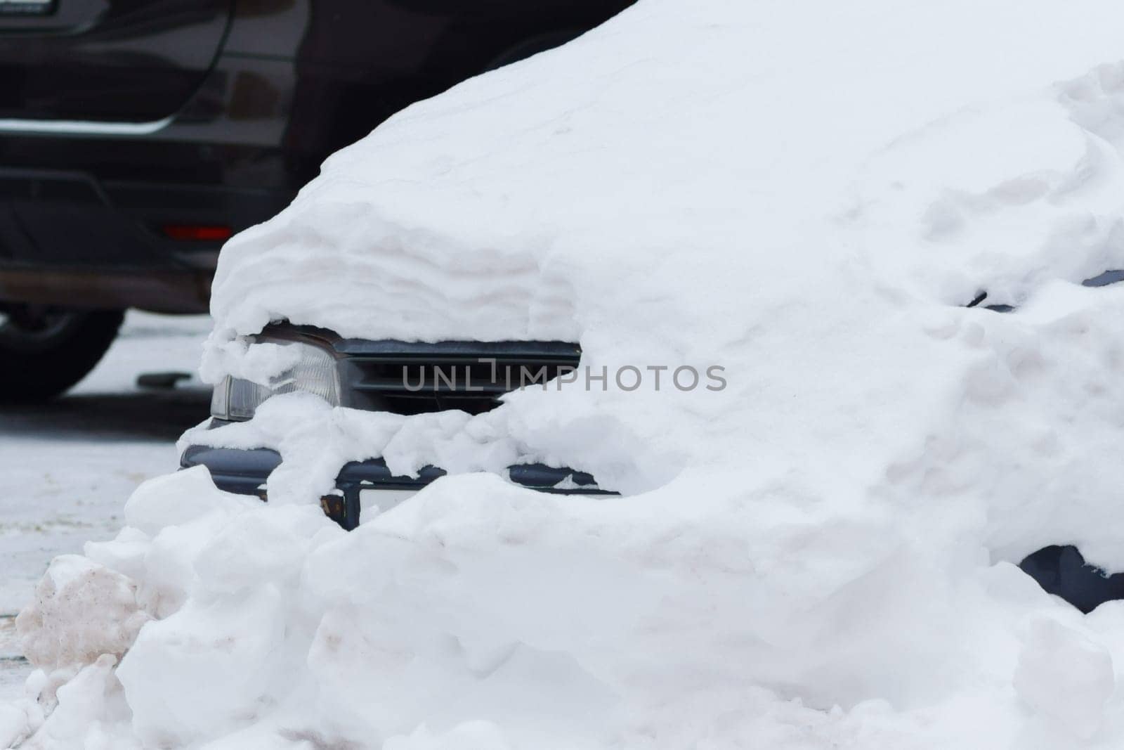 Car, blanketed in a thick layer of snow, stands as a testament to the chilly winter weather