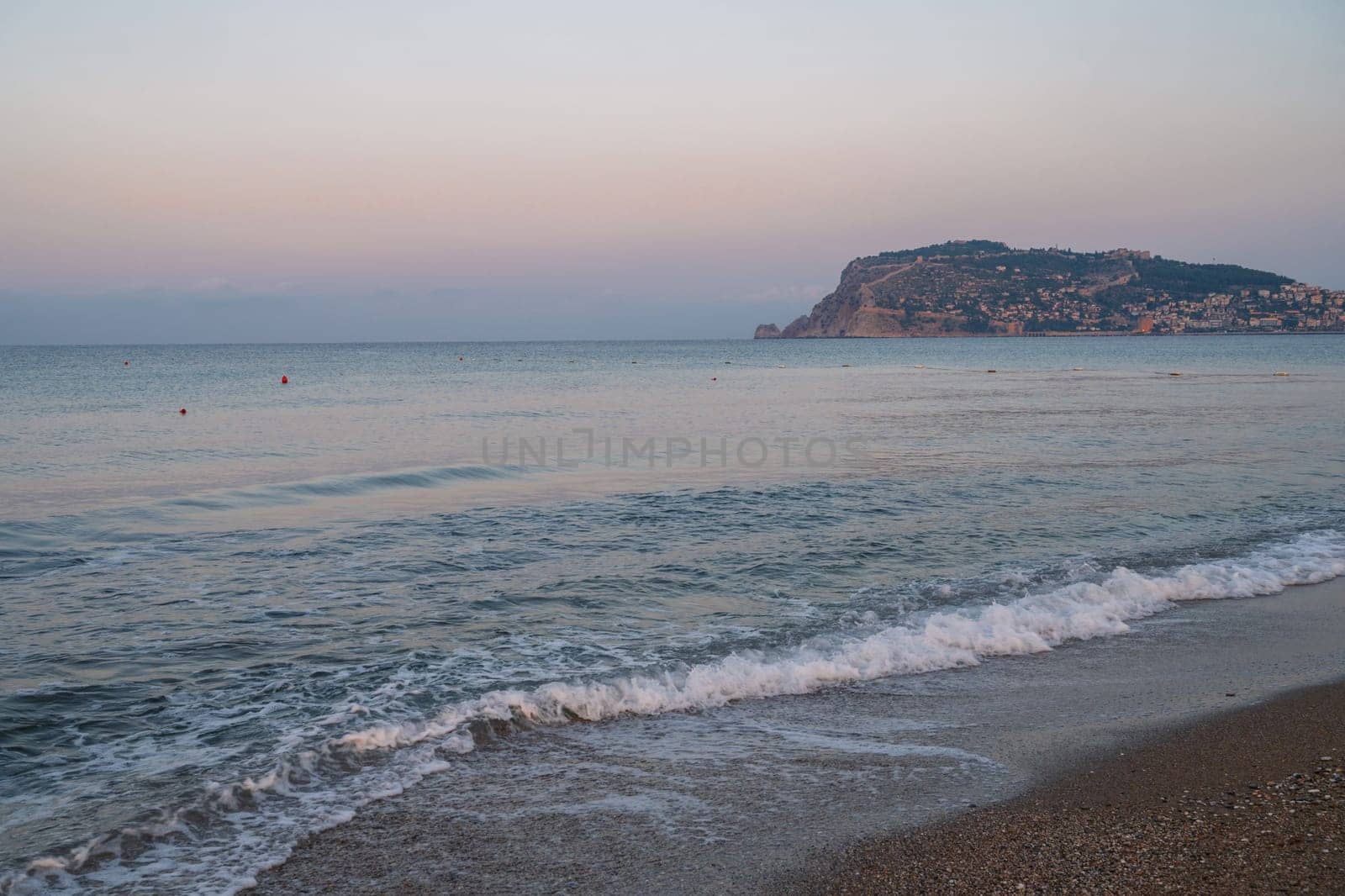 Beautiful sunrise scene on Alanya beach with view to famous Alanya island, in Turkey