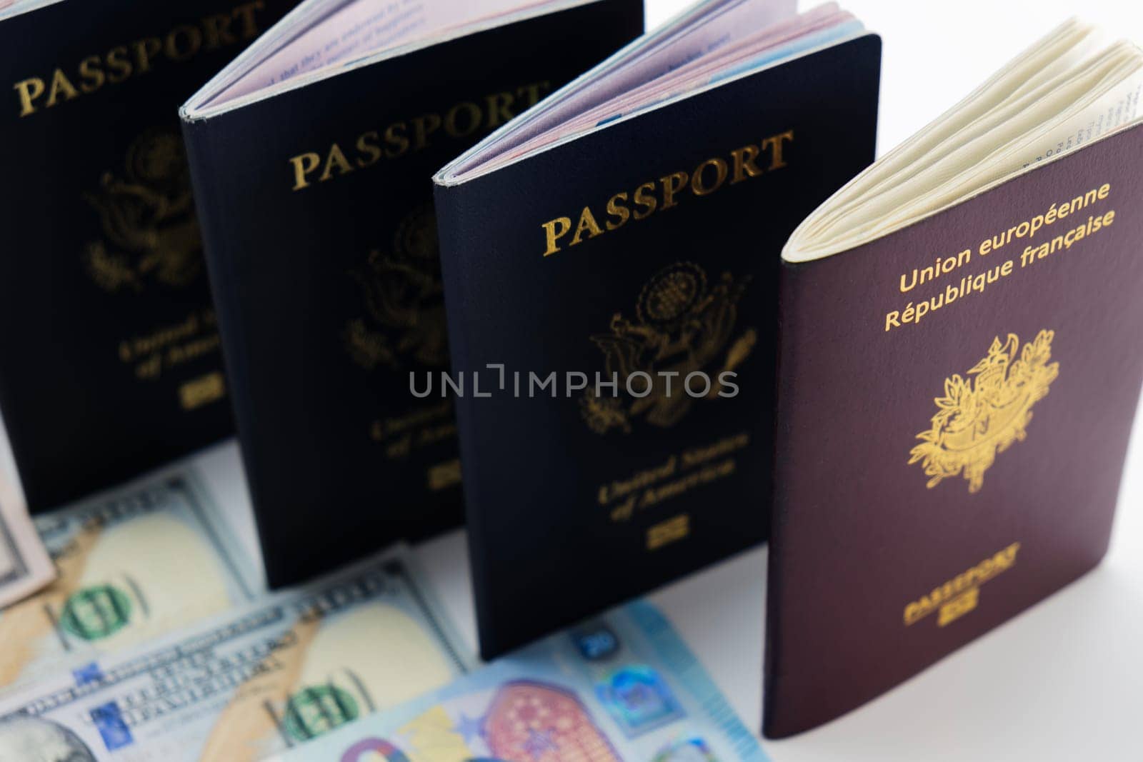 3 United States and 1 France passport on visable currency transparent background. High camera angle. Concept of business, trade, employment, vacation travel. Concept coming summer Olympics. Closeup, selective focus photo high quality photo.