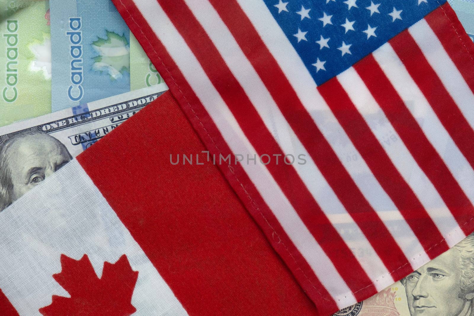 United States and Canadian flags on dollar and loonie currencies by bRollGO