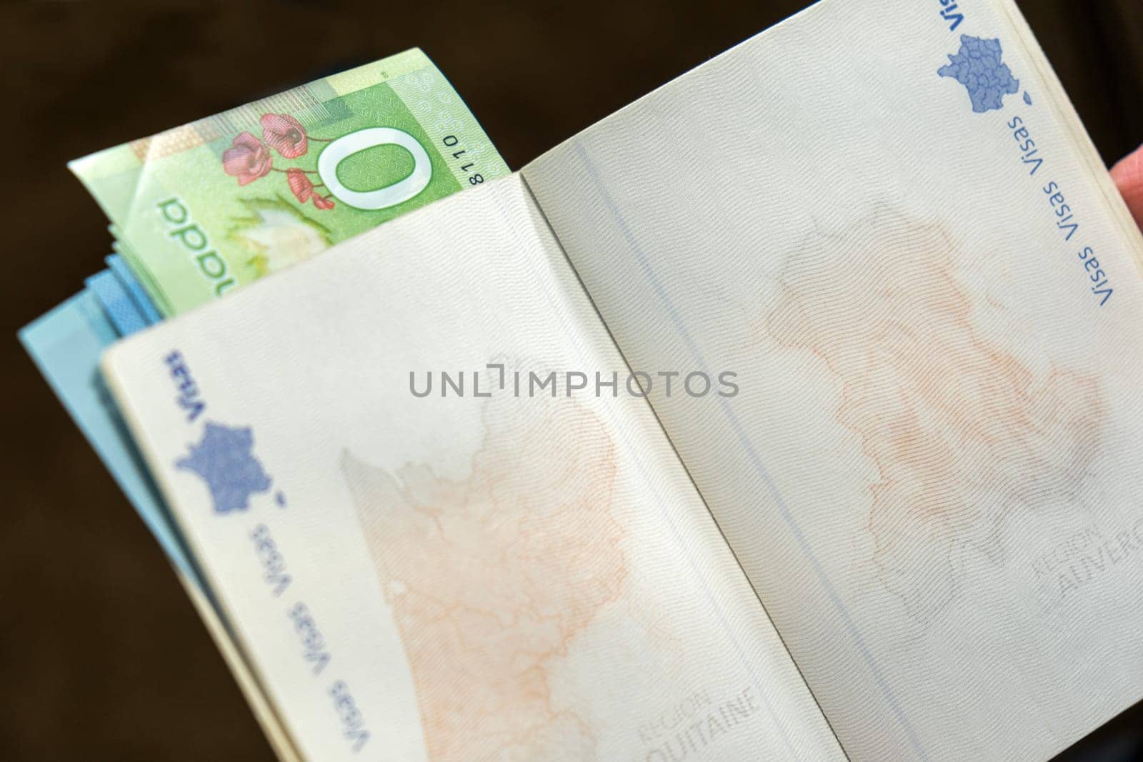 Open French passport with Euros inside on neutral background by bRollGO