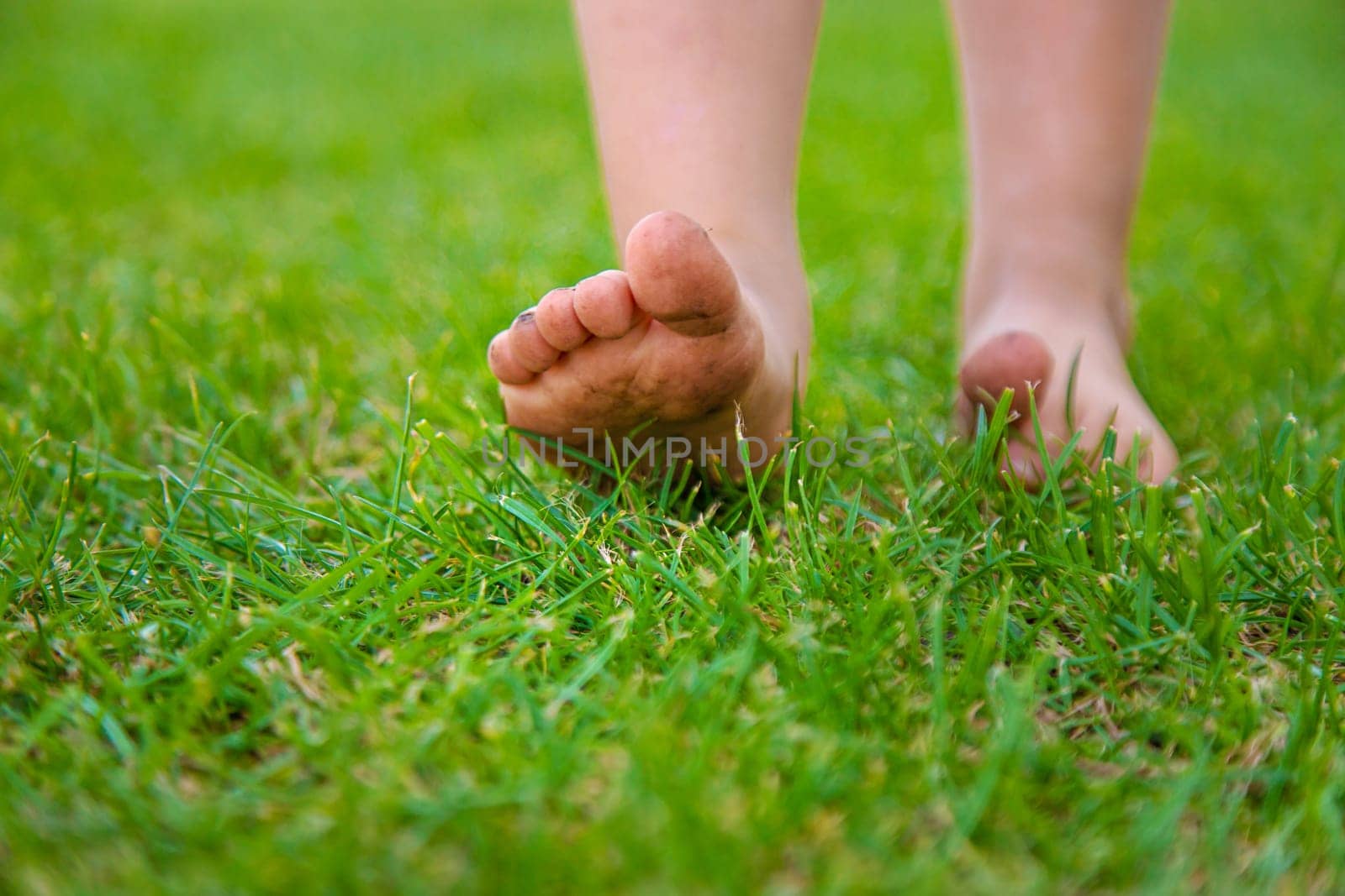 Child feet on the grass. Selective focus. Kid.