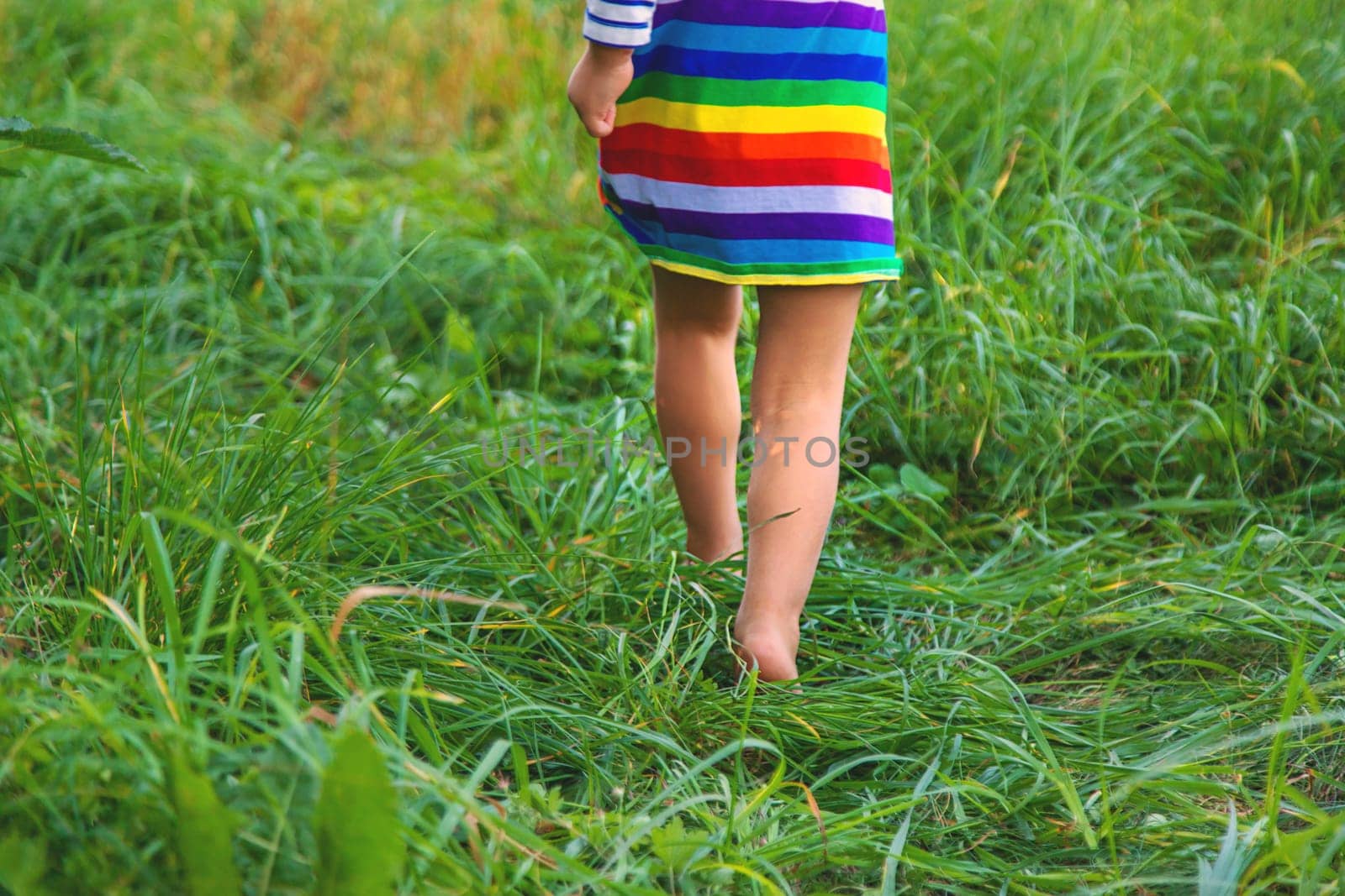 Child feet on the grass. Selective focus. by yanadjana