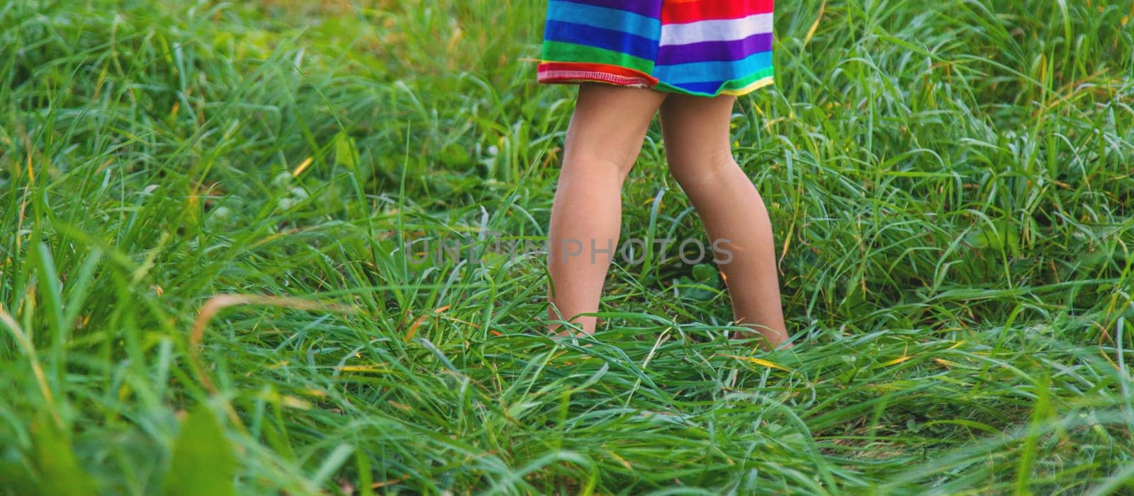 Child feet on the grass. Selective focus. Kid.