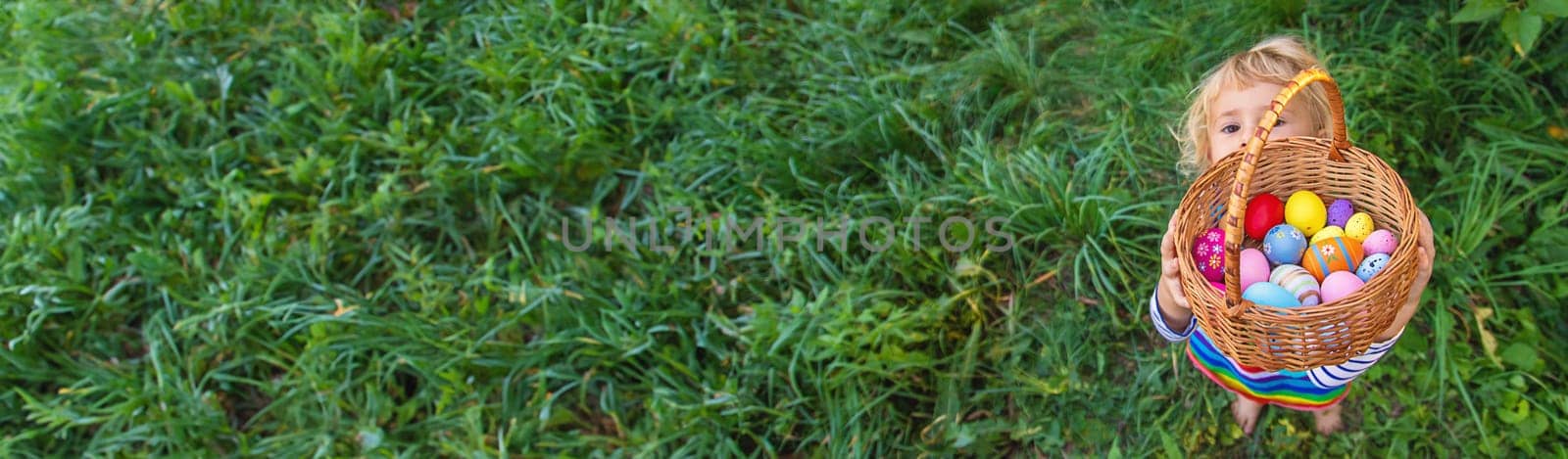 A child collects Easter eggs in the grass. Selective focus. Kid.