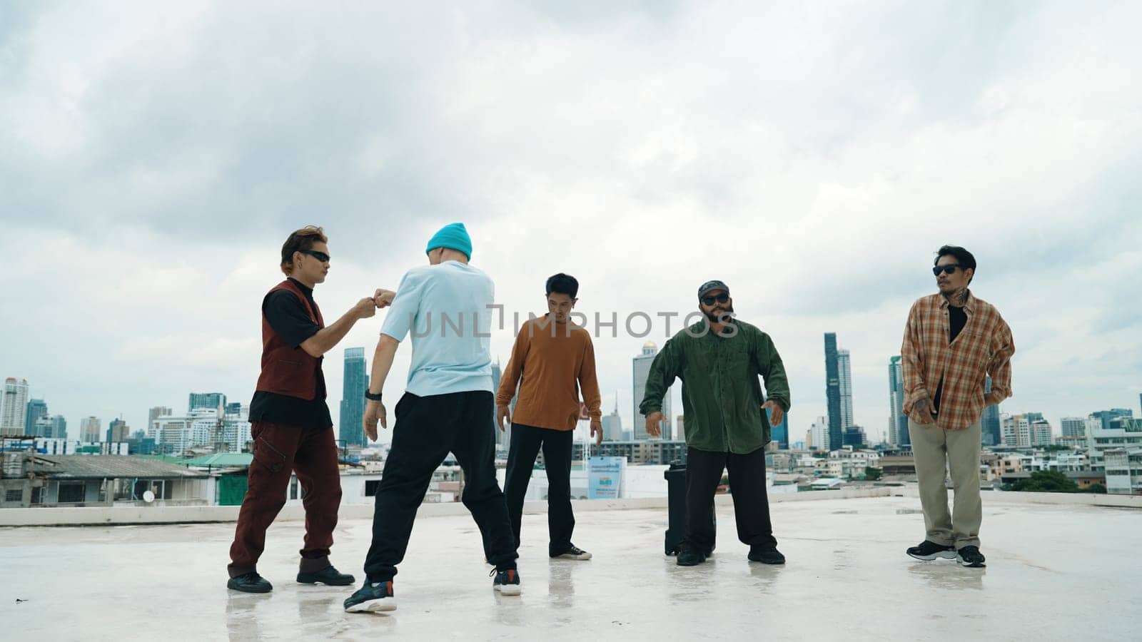 Professional break dance team practice B-boy dance while multicultural friends at rooftop. Young modern dancing group doing hip hop movement. Style,fashion,action. Outdoor sport 2024. Endeavor.