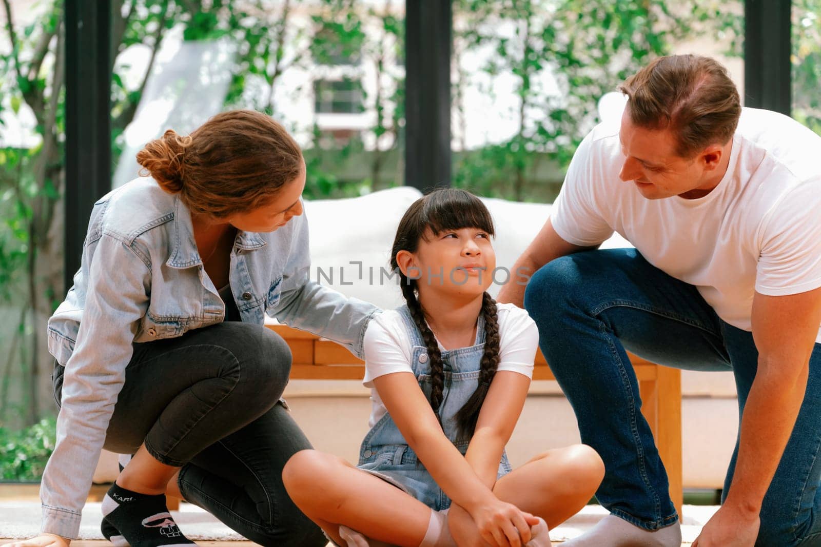 Parents comforting their daughter with loving embrace, helping her feel secure and protected as she rest her head on their shoulder. Happy family love and child care support concept. Synchronos