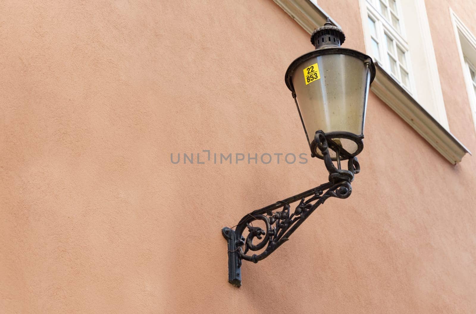 A street light is attached to the side of a building, illuminating the area around it.