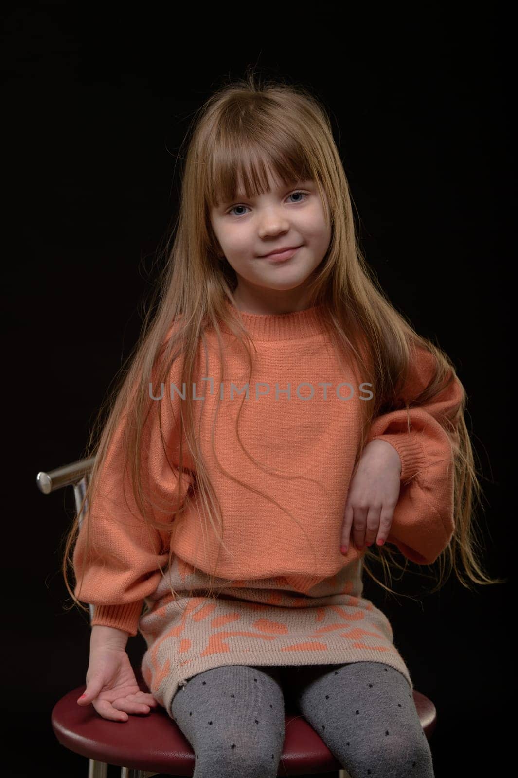 studio portrait of a charming little girl on a black background