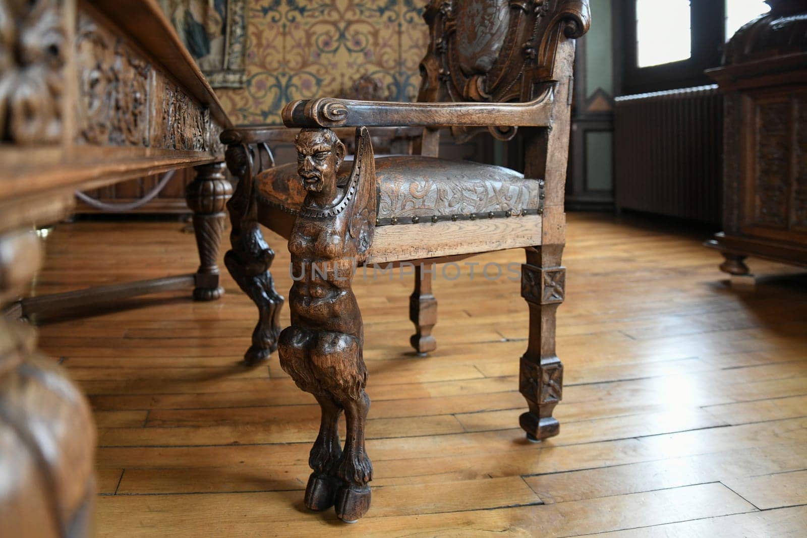 A wooden Renaissance armchair with a carved body of man