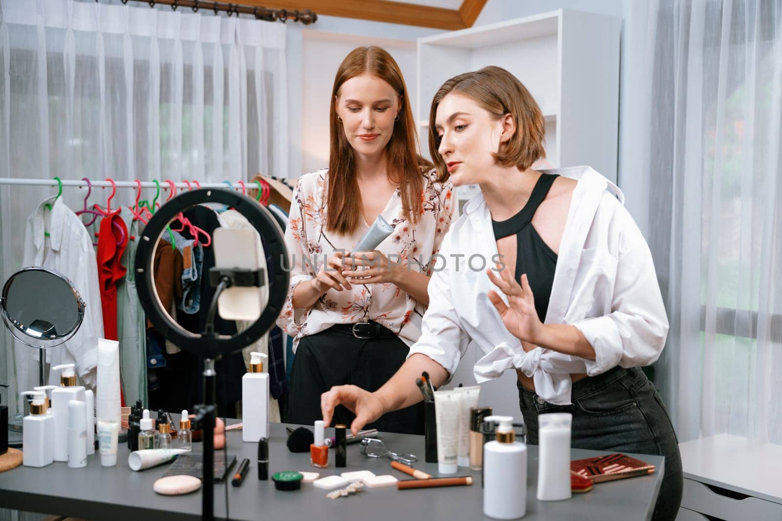 Woman influencer shoot live streaming vlog video review makeup utmost social media or blog. Happy young girl with cosmetics studio lighting for marketing recording session broadcasting online.