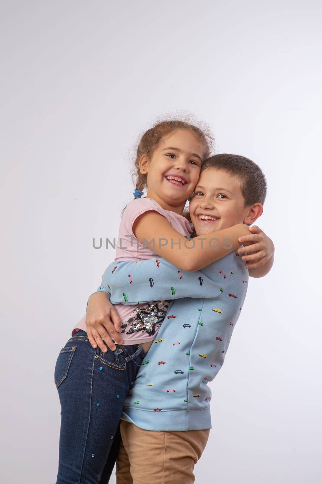 sister hugging brother studio portrait happy family