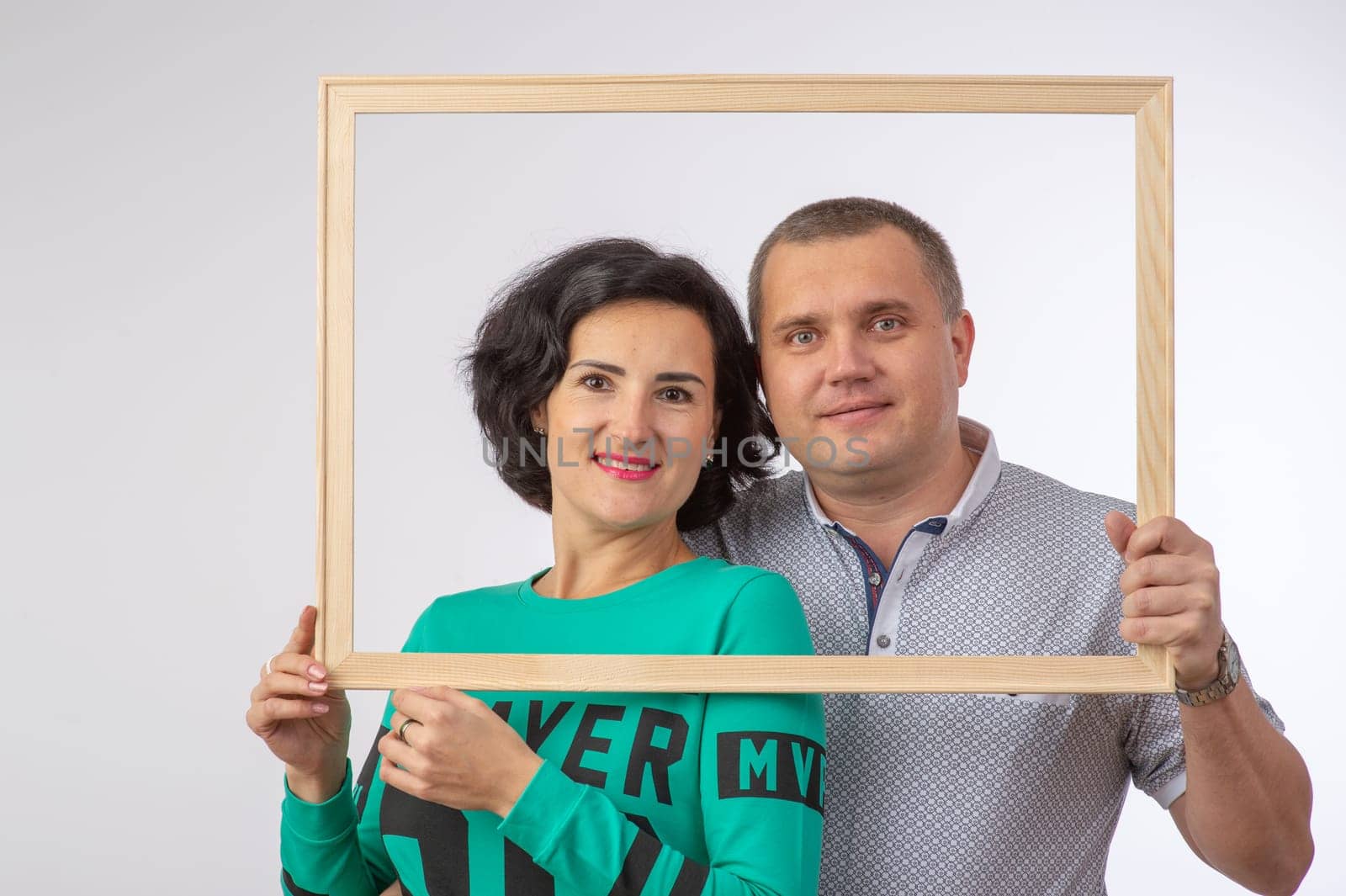 studio portrait of husband and wife in photo frame happy family 1