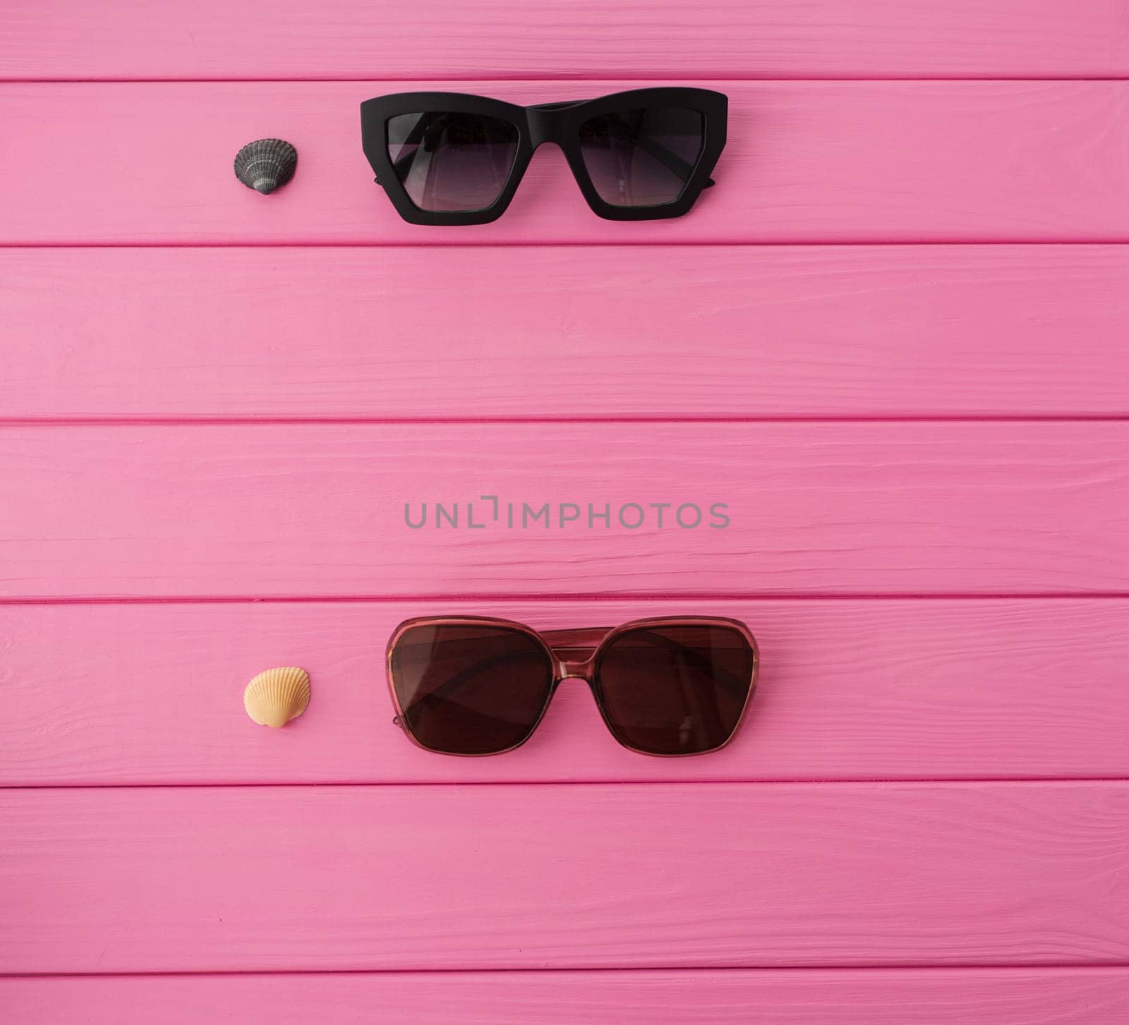 Summer abstract background mockup template free copy space for text pattern sample top view above on pink wooden board. blank empty area for inscription. Stylish sunglasses fashionable with seashells