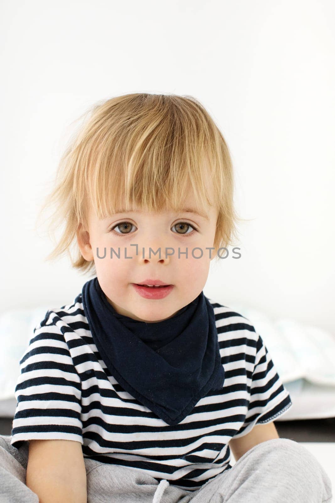 Close-up shoulder photo ID identification card little cute 2 years blonde boy isolated white background. Male kid person identity card passport. Portrait child looking at camera document striped bib