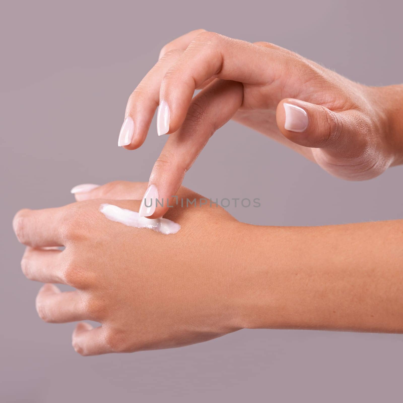 Hands, cream and beauty with woman for skincare, dermatology and wellness on grey background. Moisturizer, lotion or sunscreen with nails and manicure, antiaging cosmetic product and skin health.