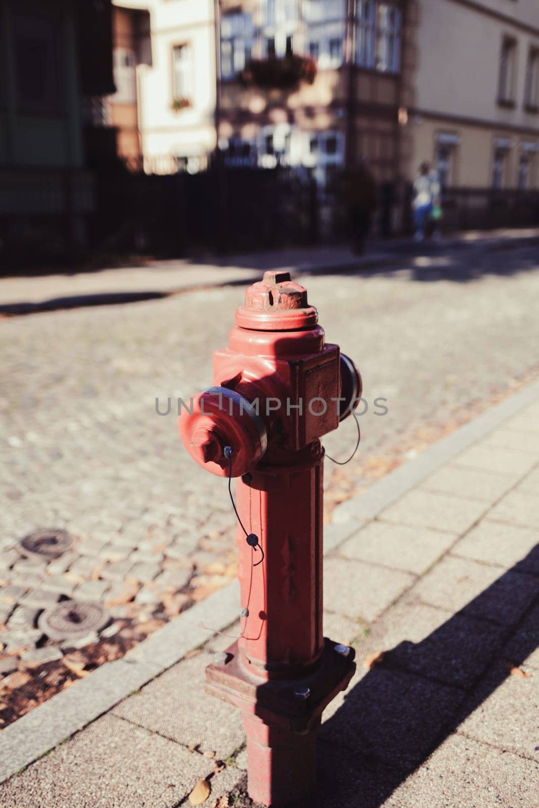 red fire hydrant in a city setting.