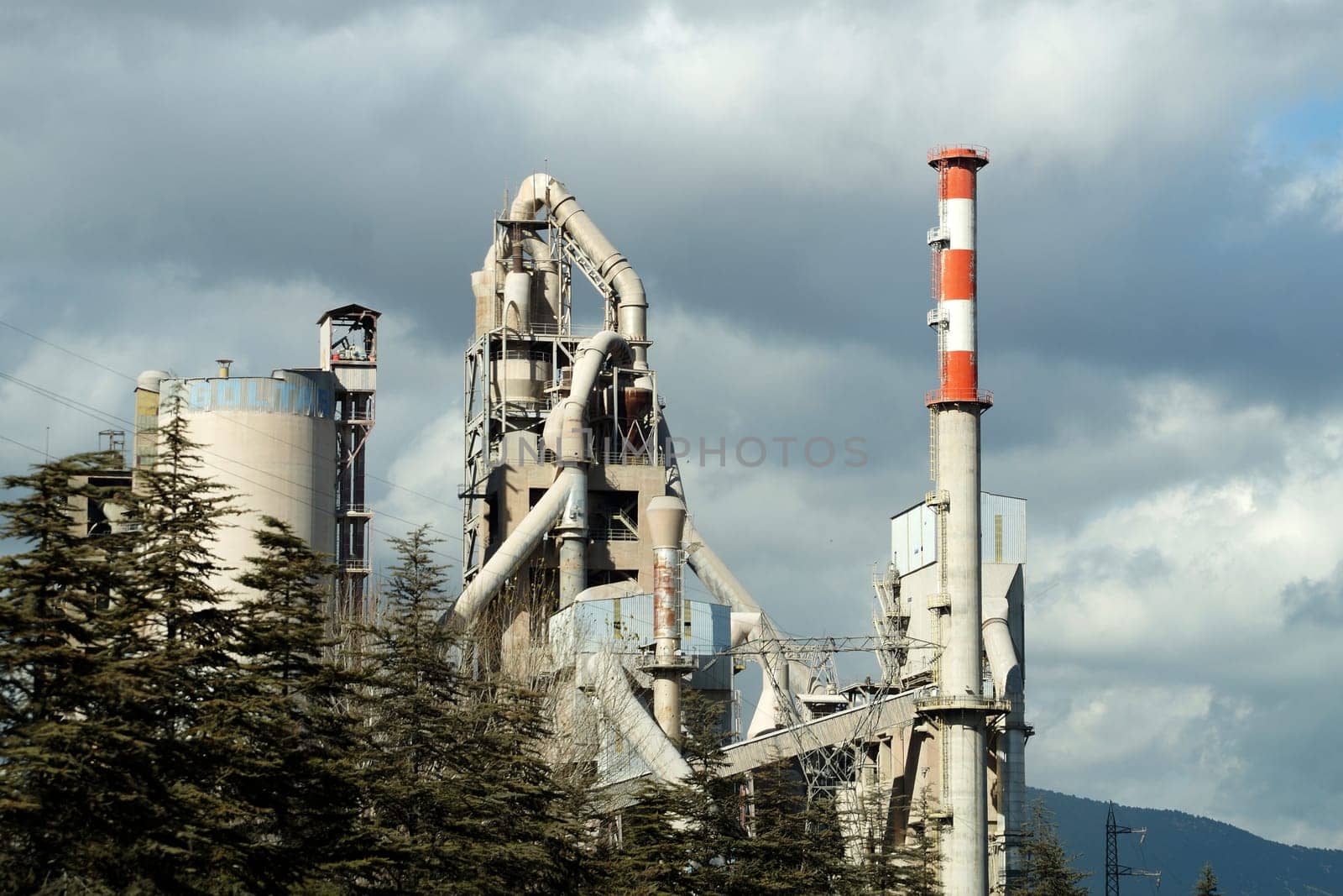 cement plant against the background of a cloudy sky close-up by Annado