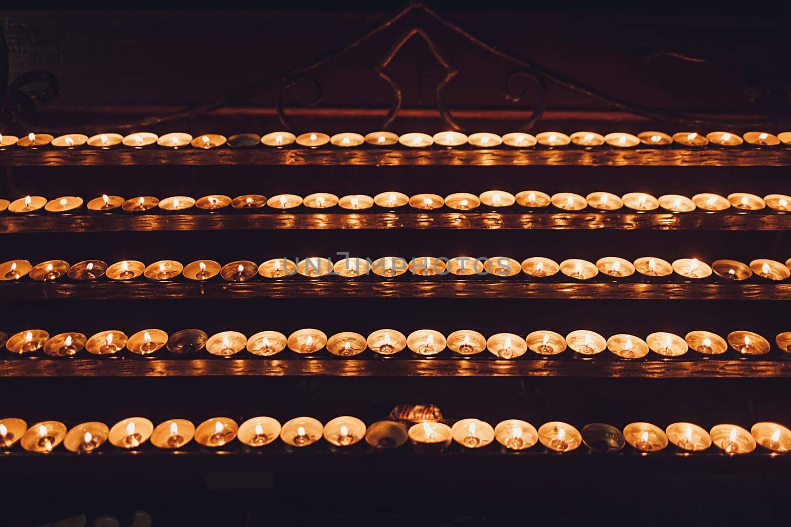 rows of wax candles in the Church