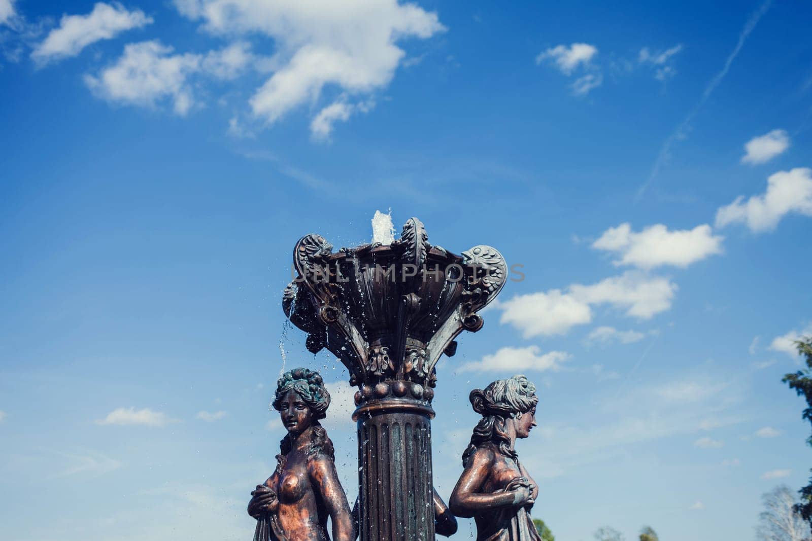 vintage bronze fountain on blue sky background