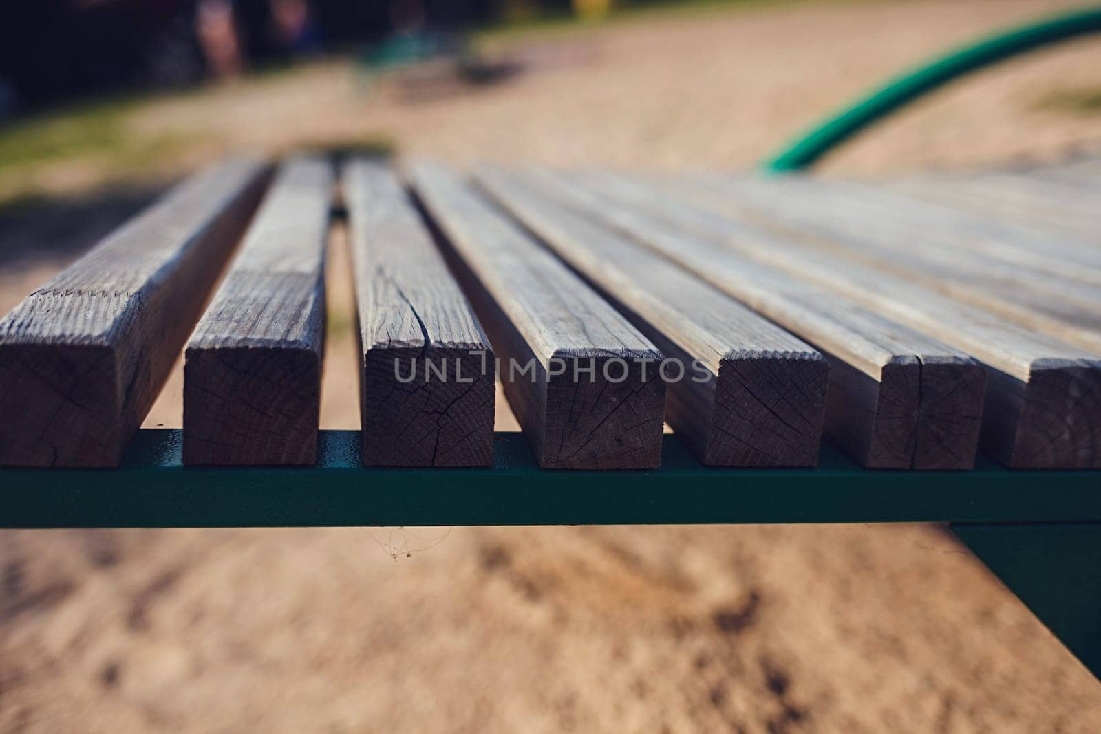 a fragment of a wooden bench made of planks with sand in the backgroun