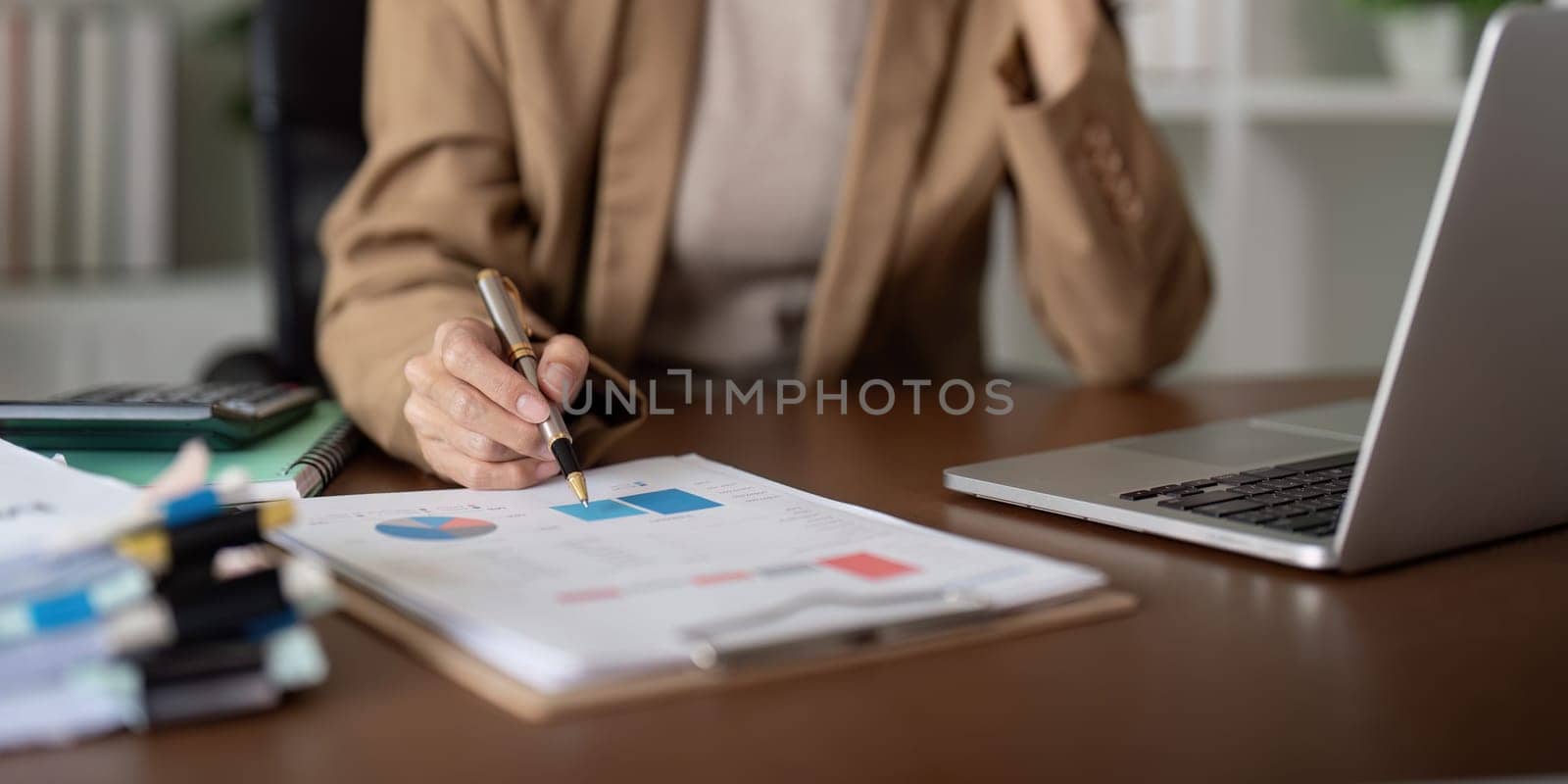 Close up business woman hand analyze to calculate the company financial and tax results the office, accounting, statistics, and analytical research.