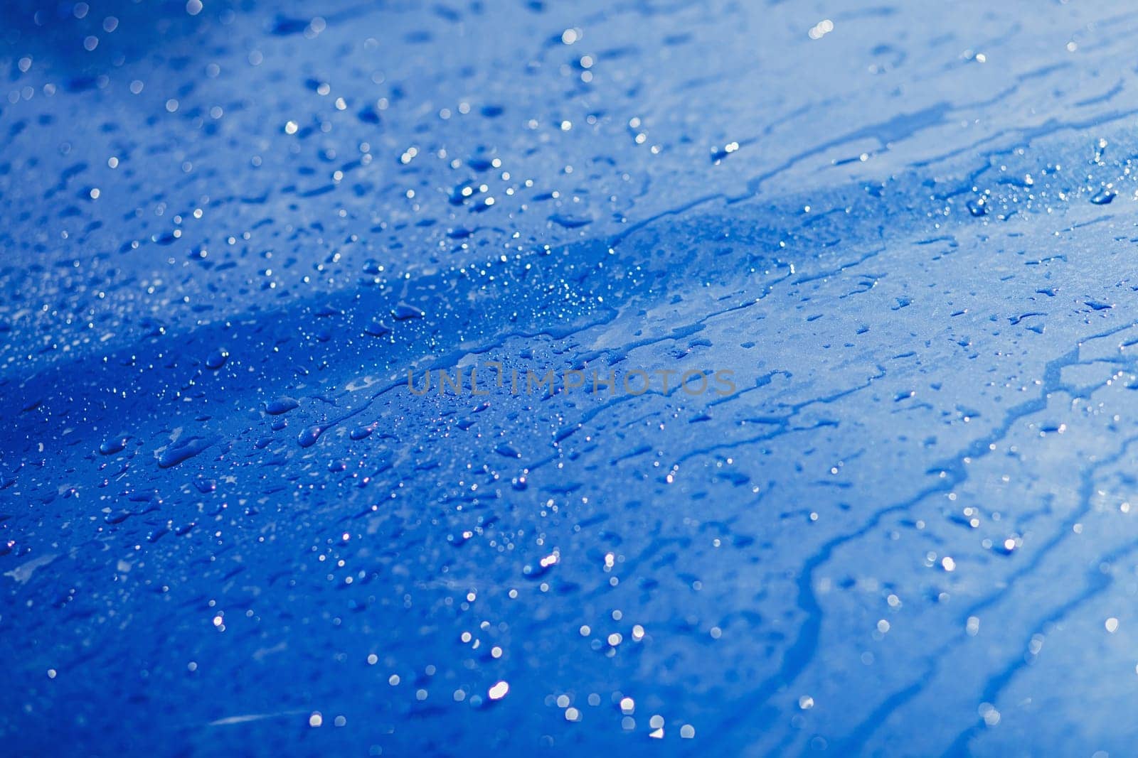 shiny water drops on a blue metallic background