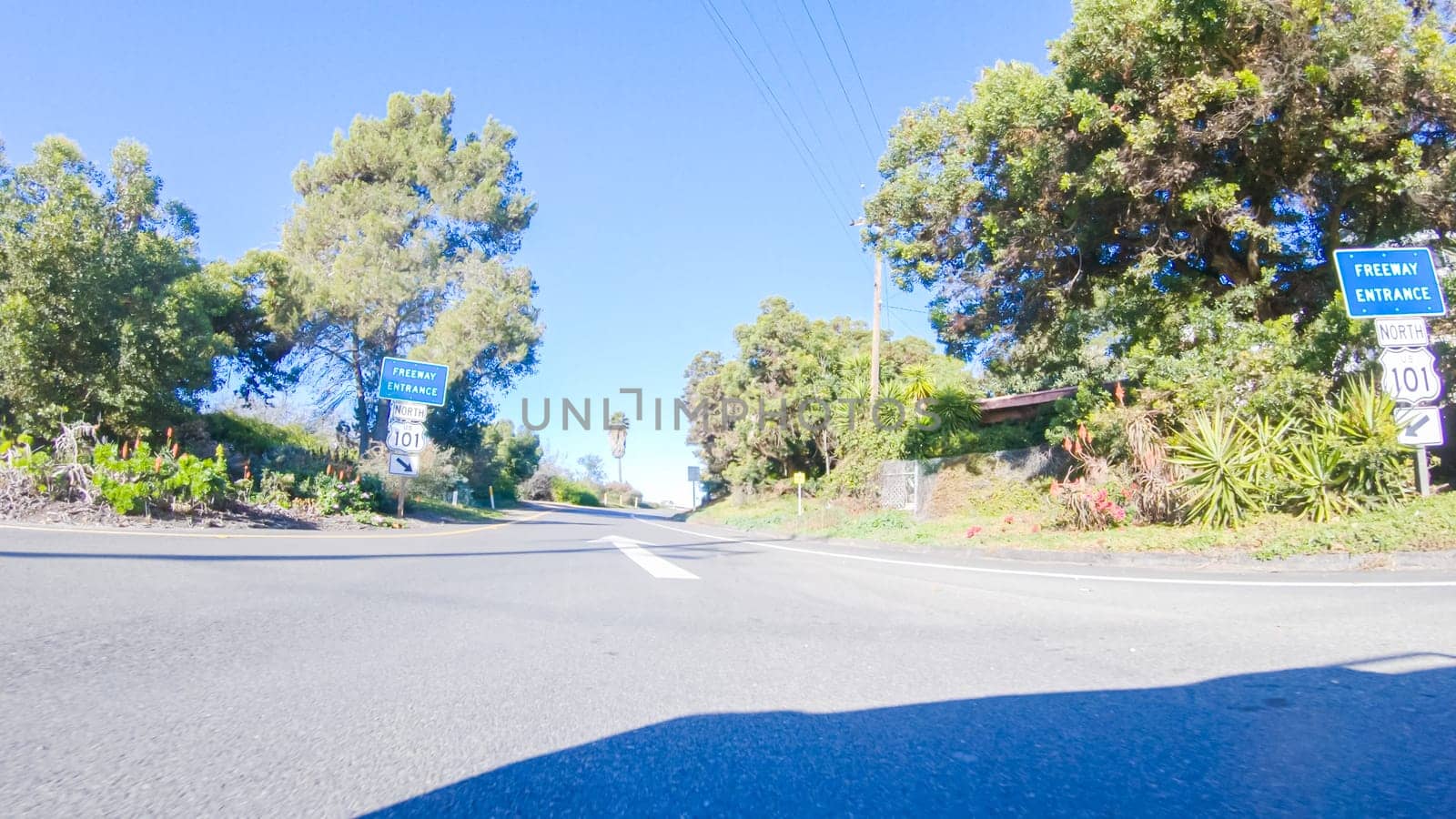 Santa Maria, California, USA-December 6, 2022-On a crisp winter day, a car cruises along the iconic Highway 1 near San Luis Obispo, California. The surrounding landscape is brownish and subdued, with rolling hills and patches of coastal vegetation flanking the winding road.