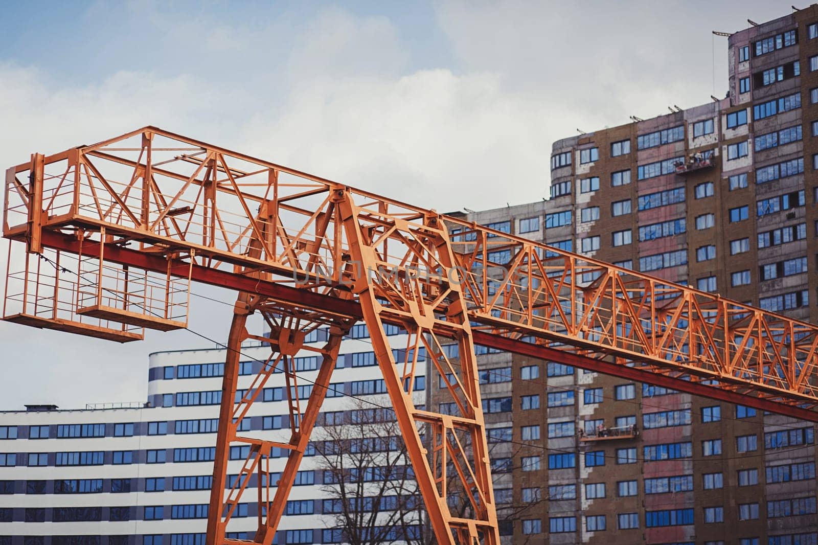 large yellow crane on the background of a new house under construction