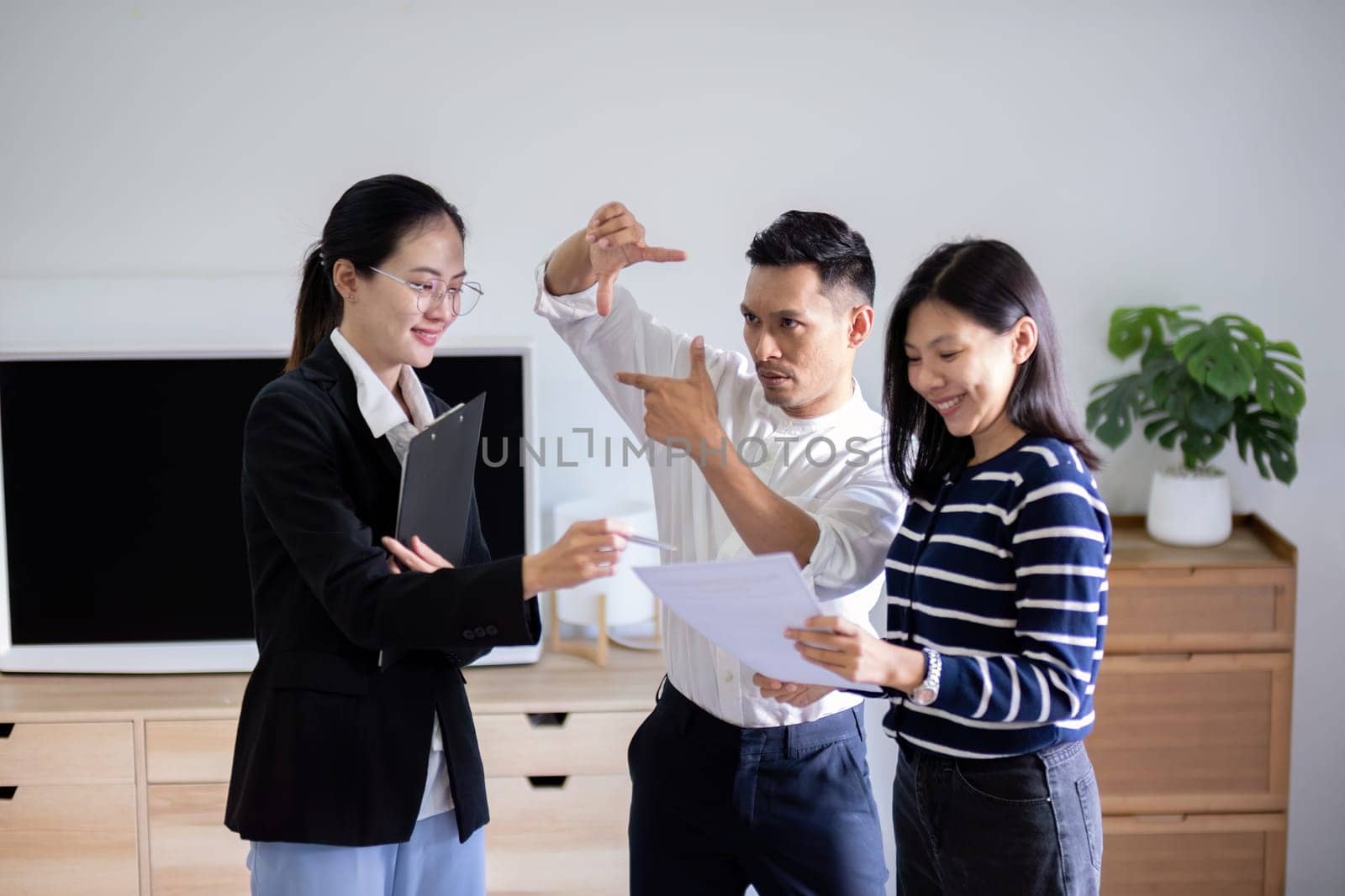 Real estate agent giving buy or tenant tour about big new house. Couple or husband and wife who plan property investment looking at home.