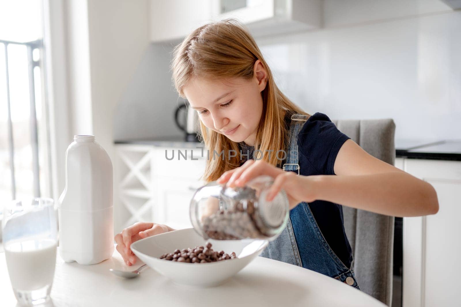 Cute Girl Pours Cereal Into Plate For Breakfast by tan4ikk1