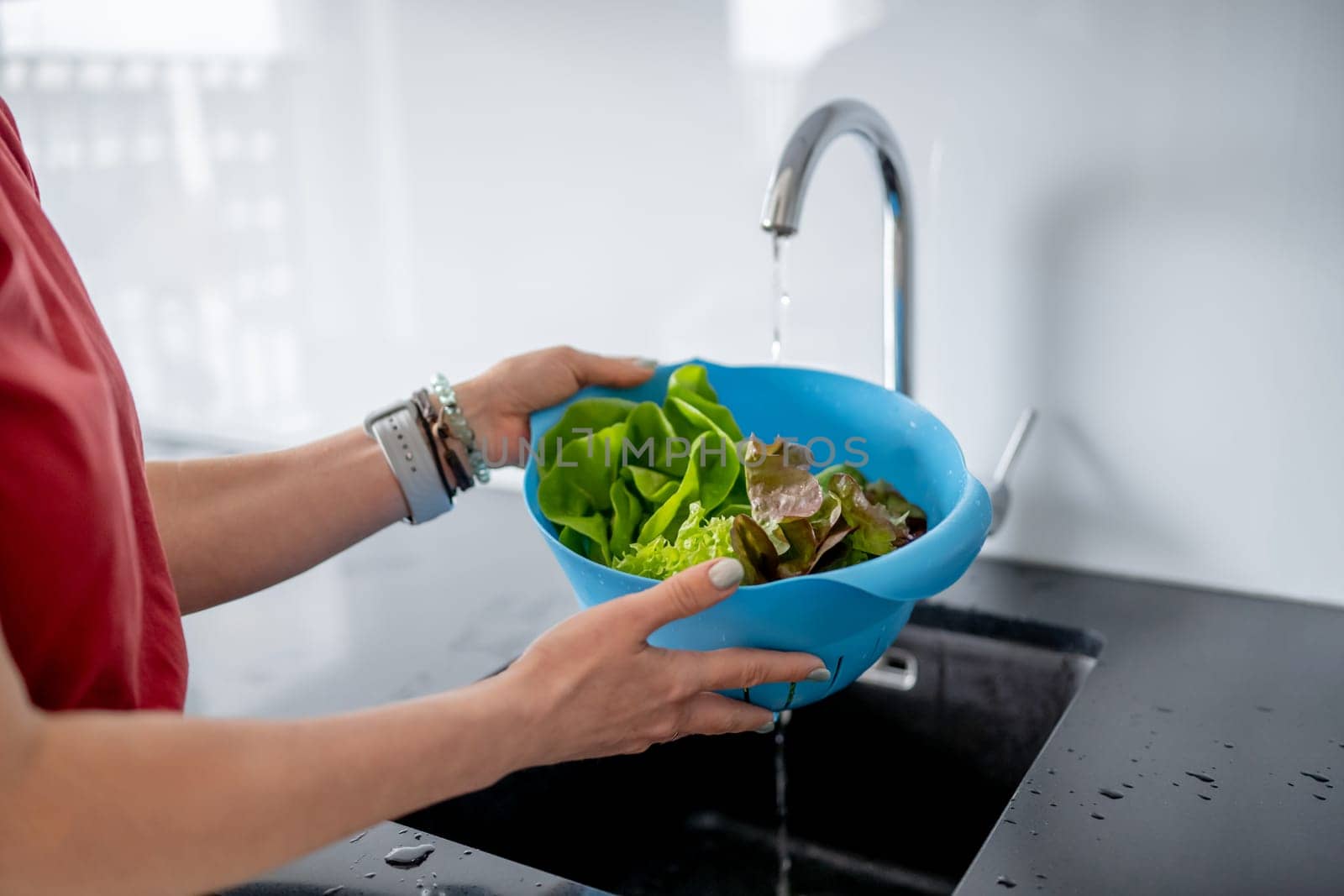 Young Woman In Kitchen Washes Lettuce Leaves In Close-Up View